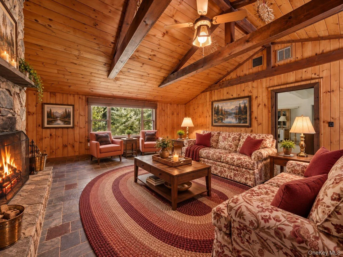 Virtually staged family room highlighting the vaulted wood ceiling, exposed beams, stone fireplace, and generous seating area. Virtually staged family room highlighting the vaulted wood ceiling, exposed beams, stone fireplace, and generous seating area.