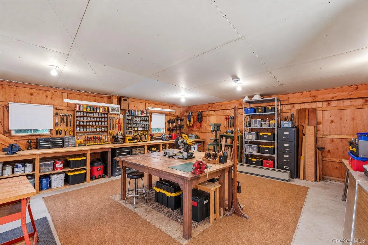 Virtually Staged. Workroom showcasing the extensive shelving, workbenches, and flexible space for projects, hobbies, or storage. Virtually Staged. Workroom showcasing the extensive shelving, workbenches, and flexible space for projects, hobbies, or storage.