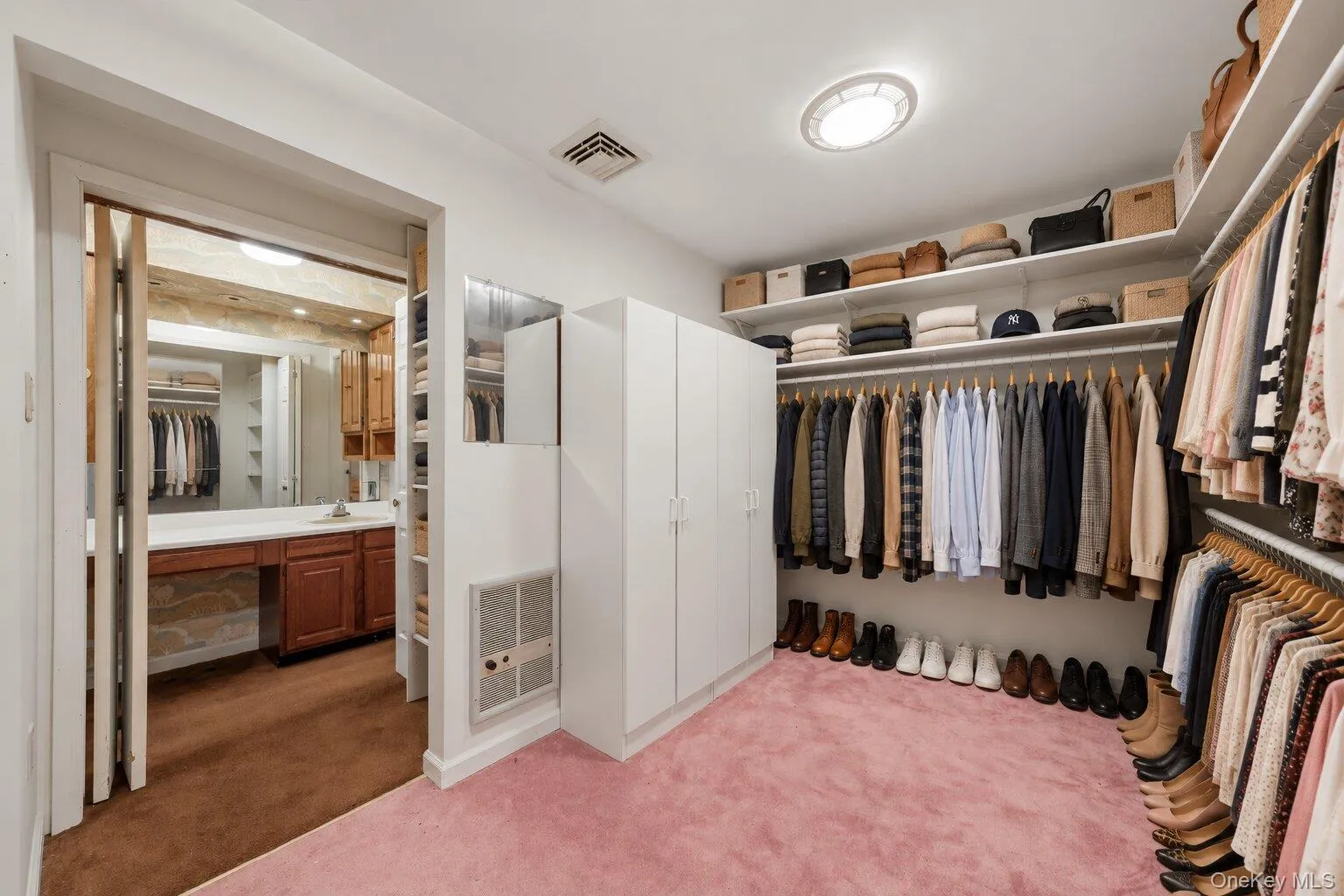 Virtually organized walk-in closet highlighting the extensive hanging space, shelving, and convenient bathroom access. Virtually organized walk-in closet highlighting the extensive hanging space, shelving, and convenient bathroom access.