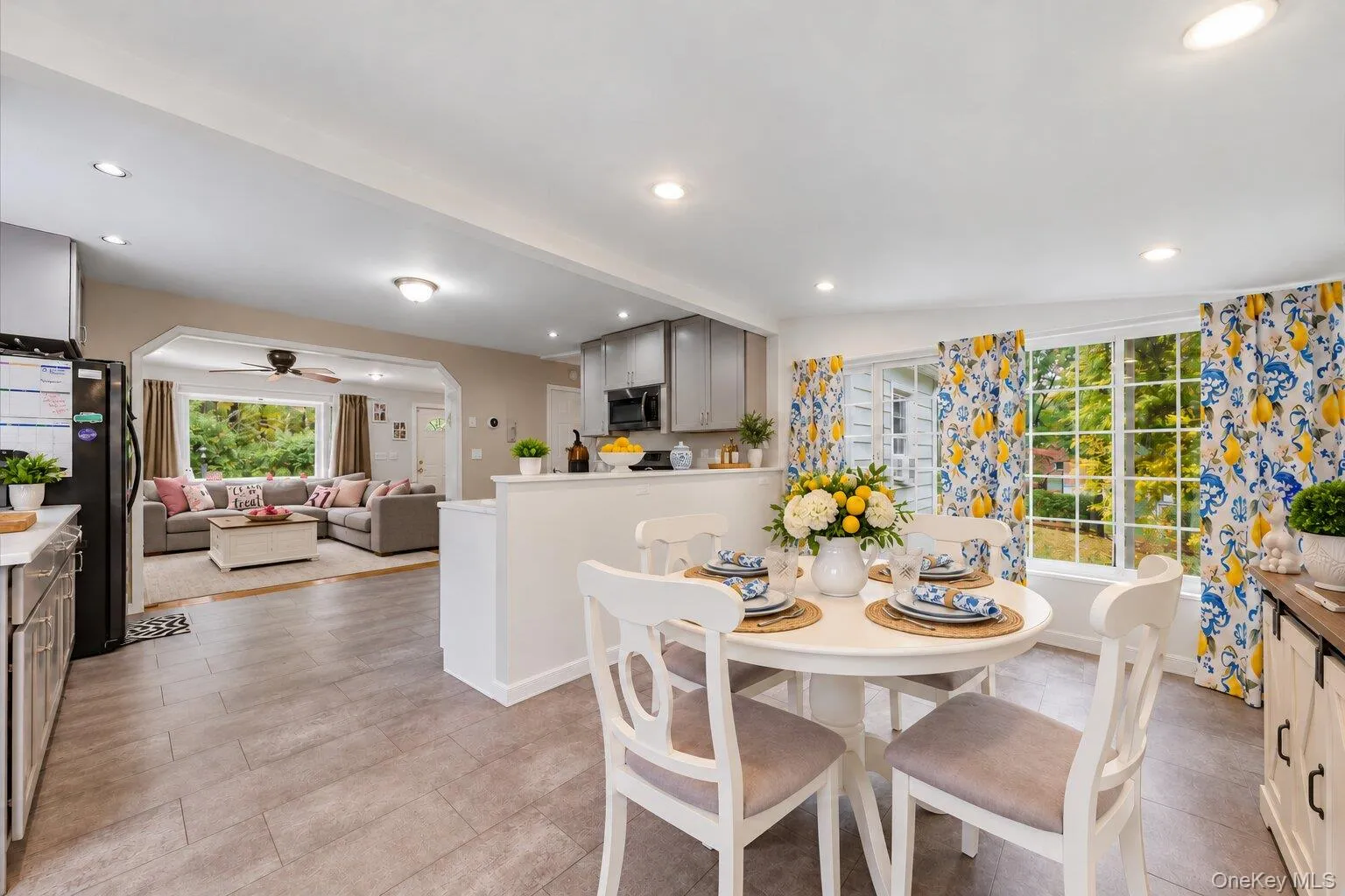 Virtually decluttered and the table has been set. Bright, open dining area with large windows, a round dining table, and easy access to the kitchen and living room. Virtually decluttered and the table has been set. Bright, open dining area with large windows, a round dining table, and easy access to the kitchen and living room.
