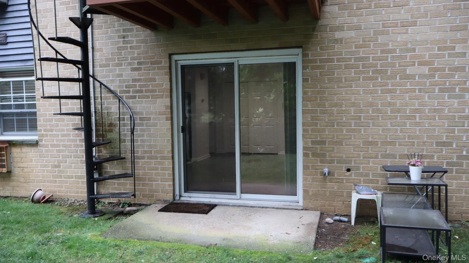 Brick exterior featuring a metal spiral staircase and a sliding glass door Brick exterior featuring a metal spiral staircase and a sliding glass door