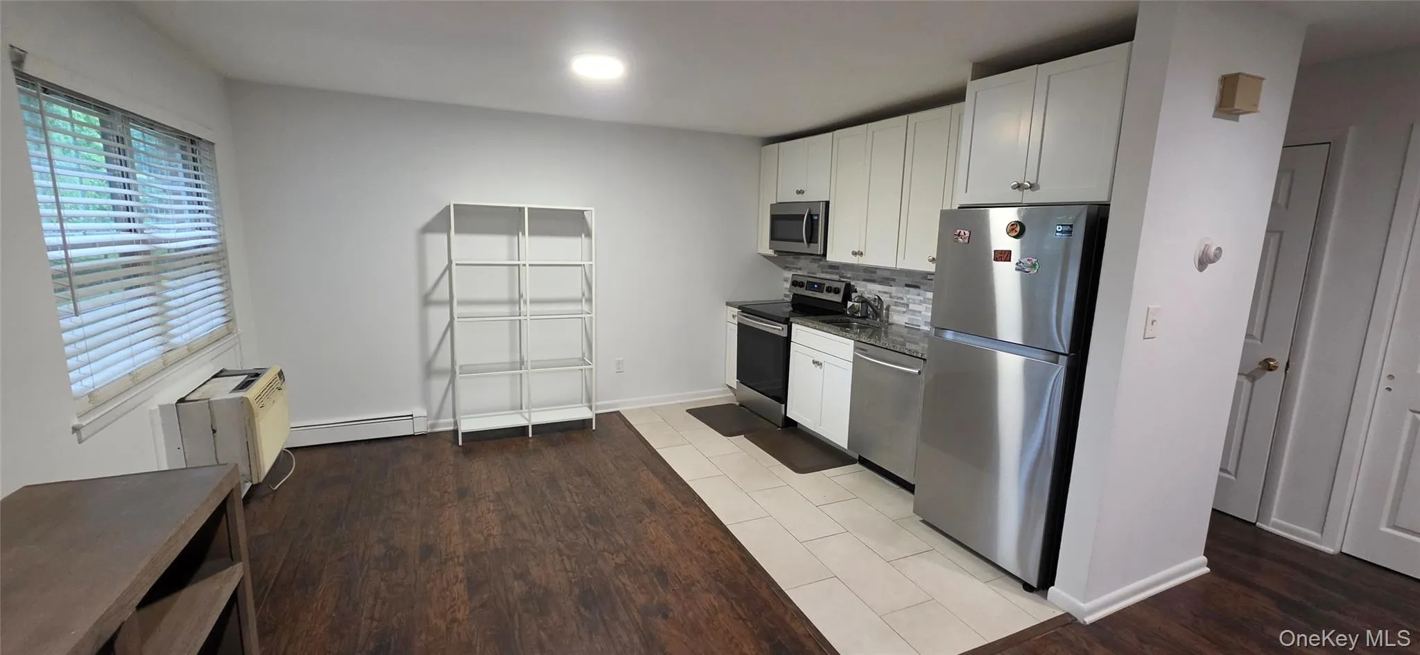 Kitchen area featuring stainless steel appliances, white cabinetry, and granite-style countertops Kitchen area featuring stainless steel appliances, white cabinetry, and granite-style countertops