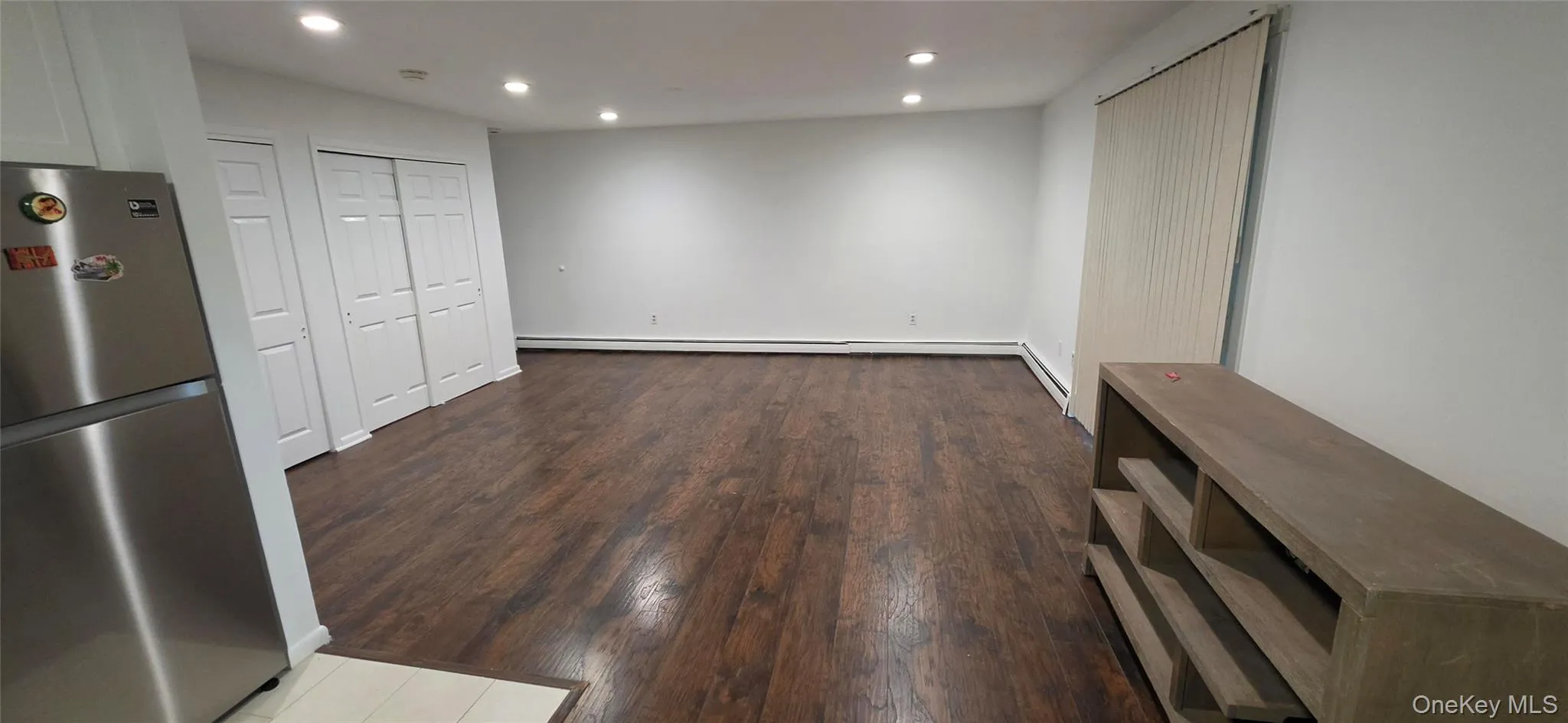 Spacious interior featuring wood-finish flooring, recessed lighting, and white walls Spacious interior featuring wood-finish flooring, recessed lighting, and white walls