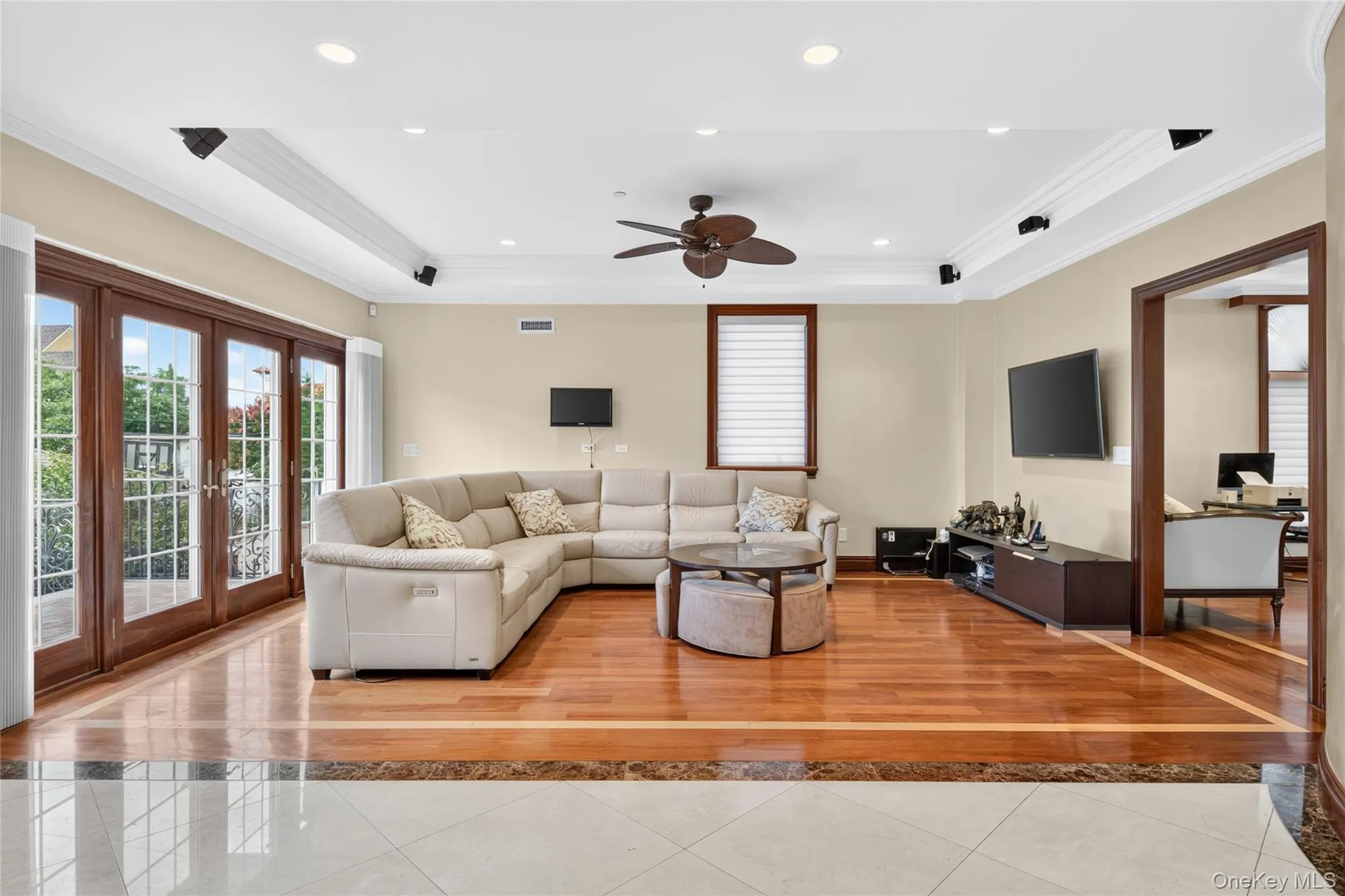 Hardwood flooring with a marble border, recessed lighting, crown molding, double French doors, and a ceiling fan Hardwood flooring with a marble border, recessed lighting, crown molding, double French doors, and a ceiling fan