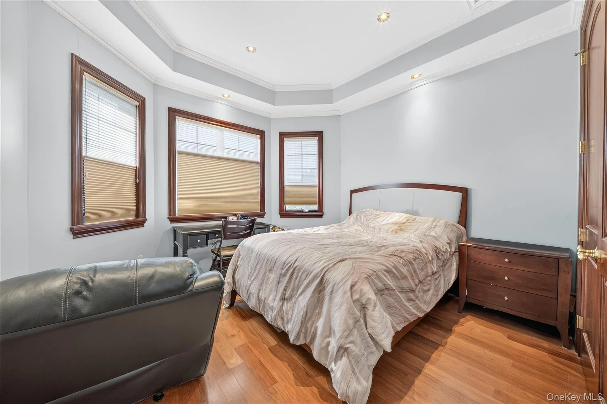 Hardwood flooring, tray ceiling with recessed lighting, multiple windows with wood trim, interior wood door Hardwood flooring, tray ceiling with recessed lighting, multiple windows with wood trim, interior wood door