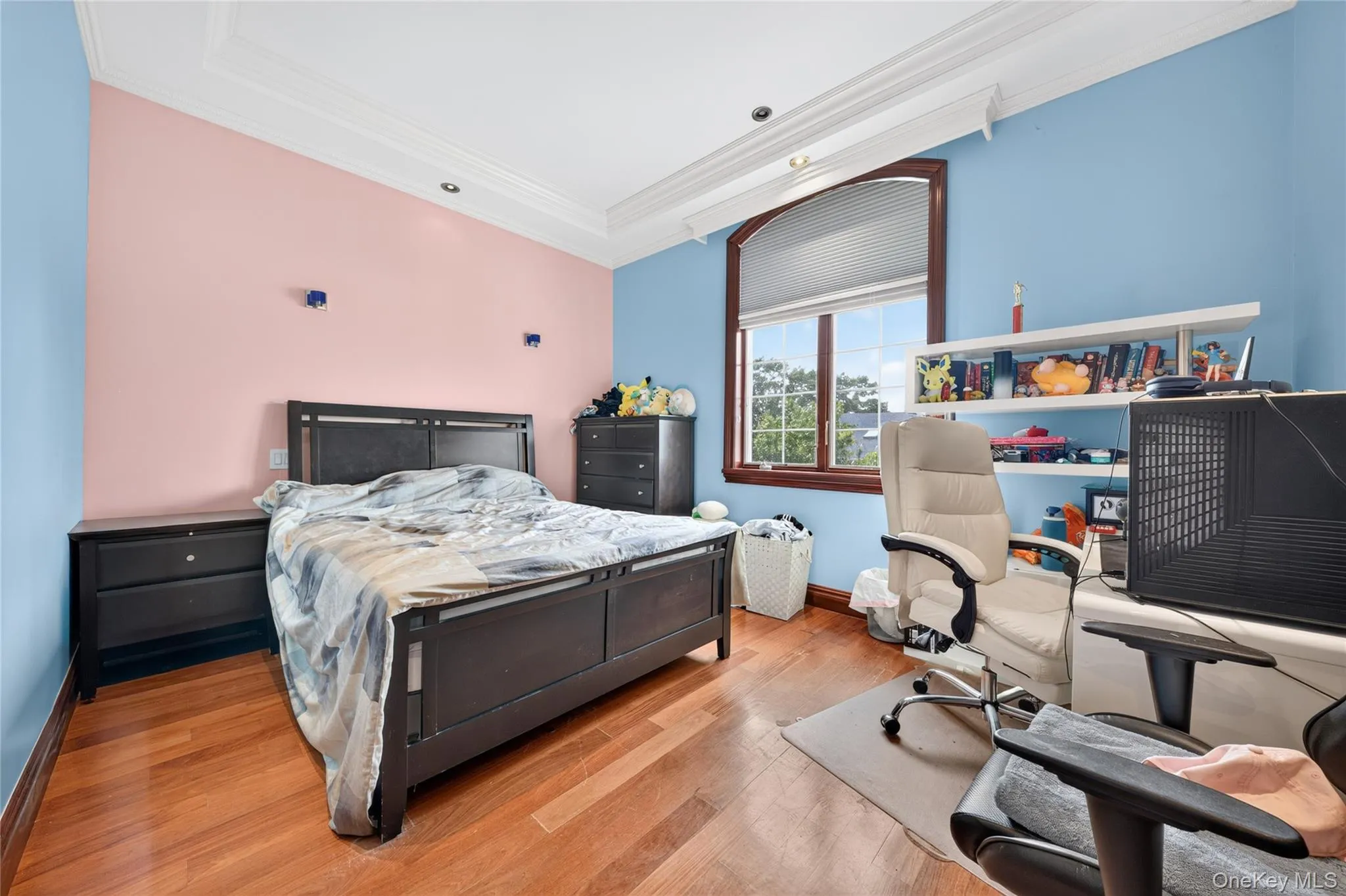 Hardwood flooring, recessed lighting, crown molding, and a large arched window with a wood frame Hardwood flooring, recessed lighting, crown molding, and a large arched window with a wood frame
