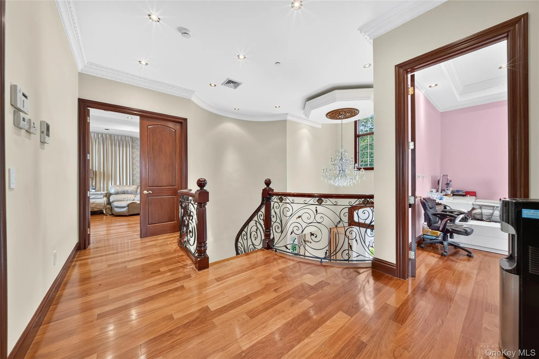 Hardwood flooring throughout, crown molding, recessed lighting, and ornate wrought iron railing Hardwood flooring throughout, crown molding, recessed lighting, and ornate wrought iron railing