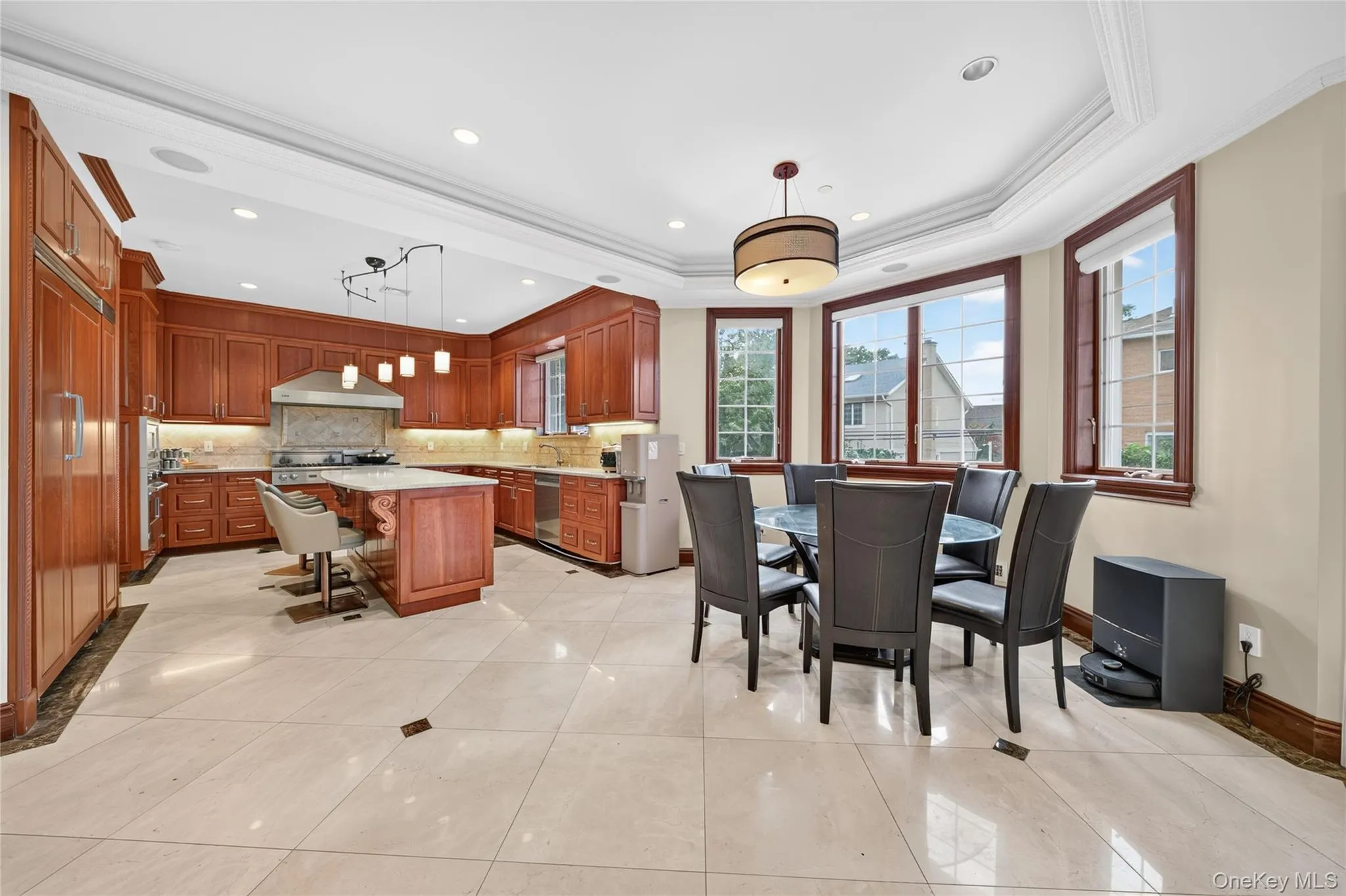 Gourmet kitchen with wood cabinetry, recessed lighting, and a center island with countertop seating Gourmet kitchen with wood cabinetry, recessed lighting, and a center island with countertop seating