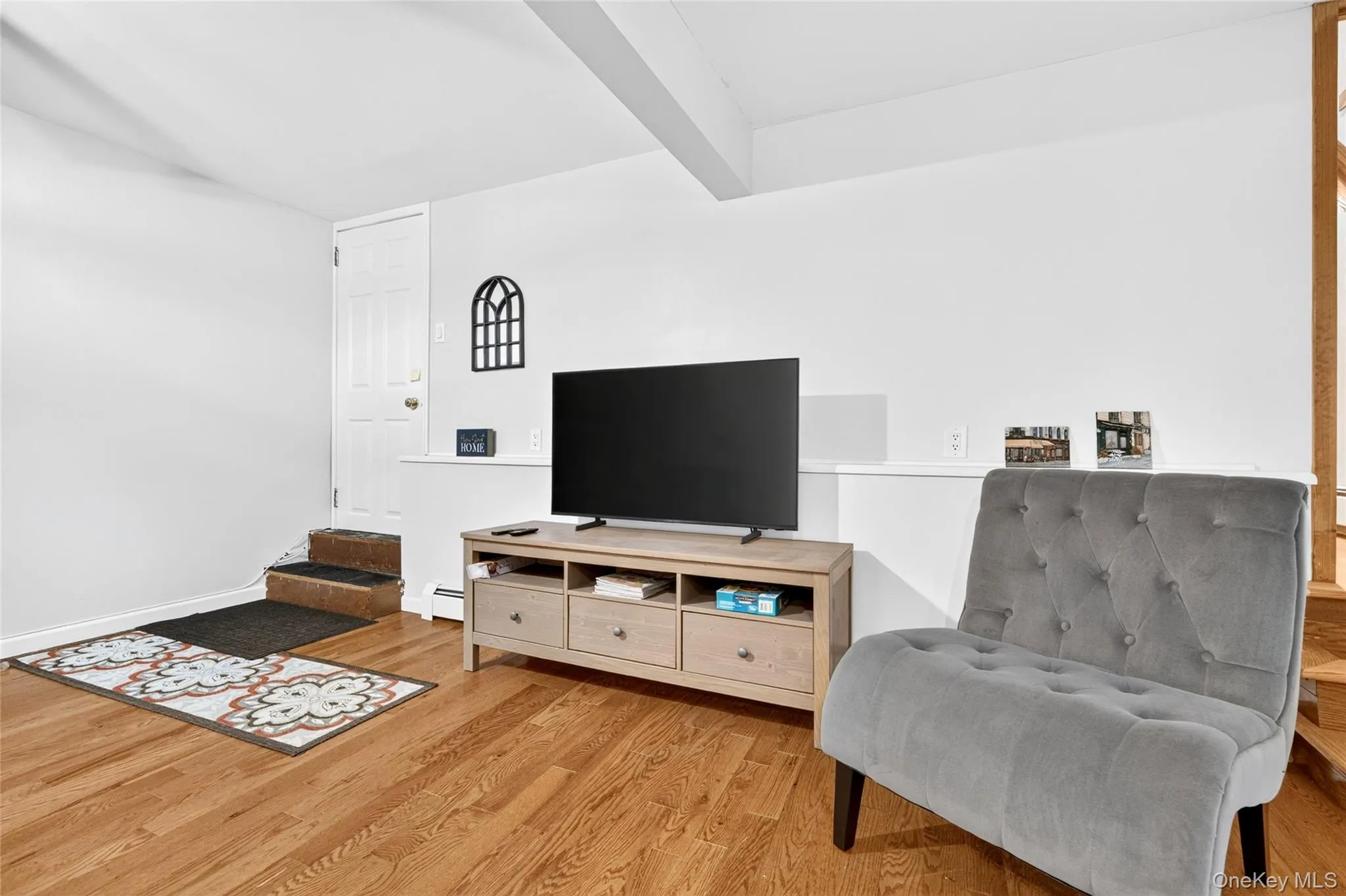 Hardwood flooring throughout, white painted walls, and a built-in partial wall Hardwood flooring throughout, white painted walls, and a built-in partial wall