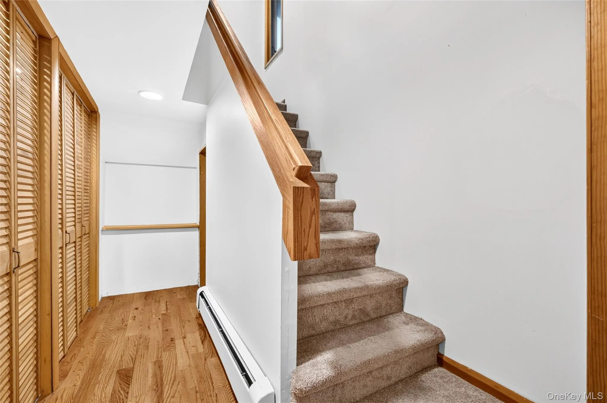 Wood-finish flooring, louvered bi-fold closet doors, carpeted staircase with wood railing, recessed ceiling lighting Wood-finish flooring, louvered bi-fold closet doors, carpeted staircase with wood railing, recessed ceiling lighting