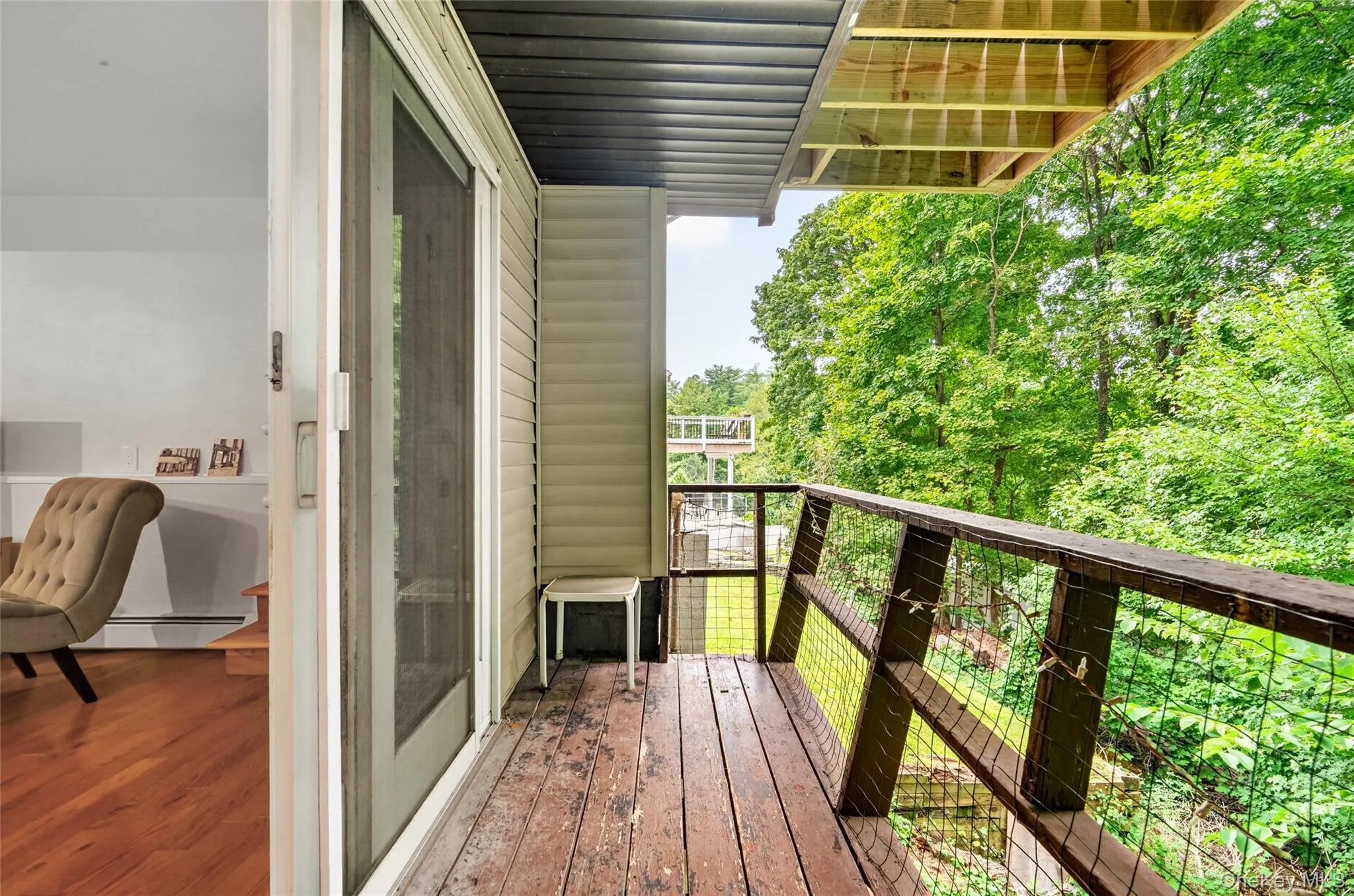 Private porch with wood deck flooring, wood and wire railing, and direct outdoor access Private porch with wood deck flooring, wood and wire railing, and direct outdoor access