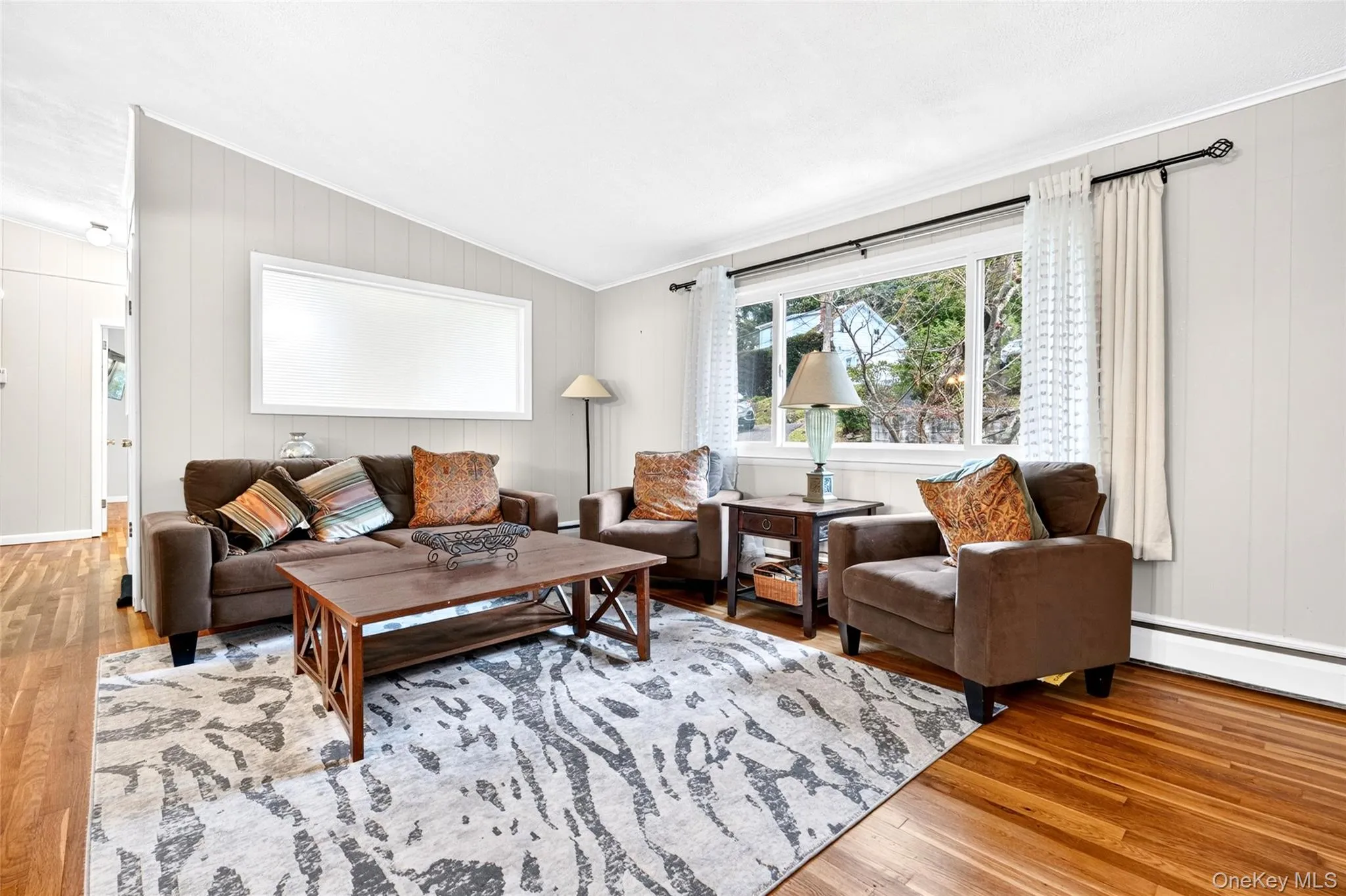 Wood-finish flooring, panel accent walls, and a large picture window Wood-finish flooring, panel accent walls, and a large picture window