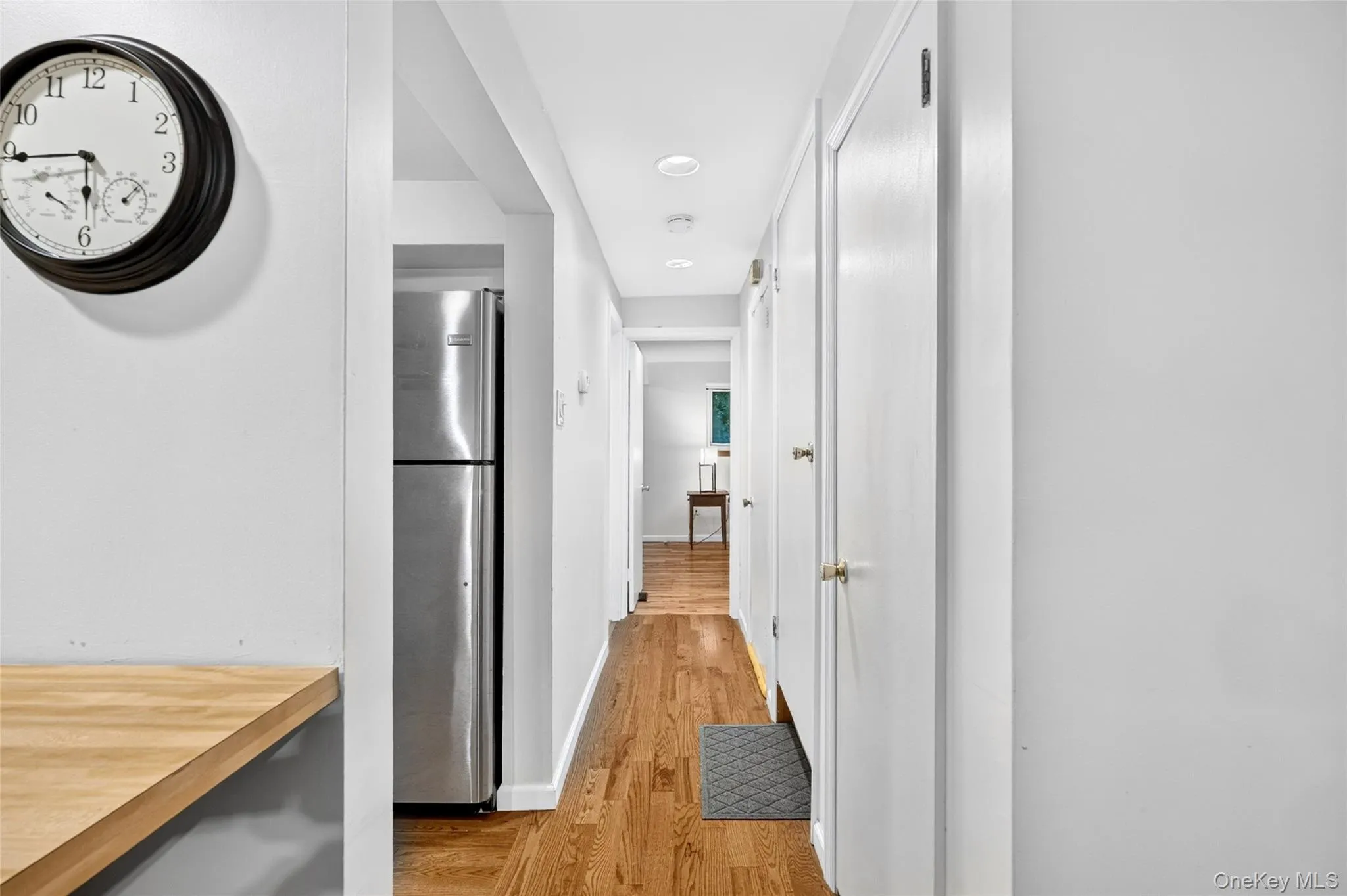 Hardwood flooring, recessed lighting, and white paneled doors Hardwood flooring, recessed lighting, and white paneled doors
