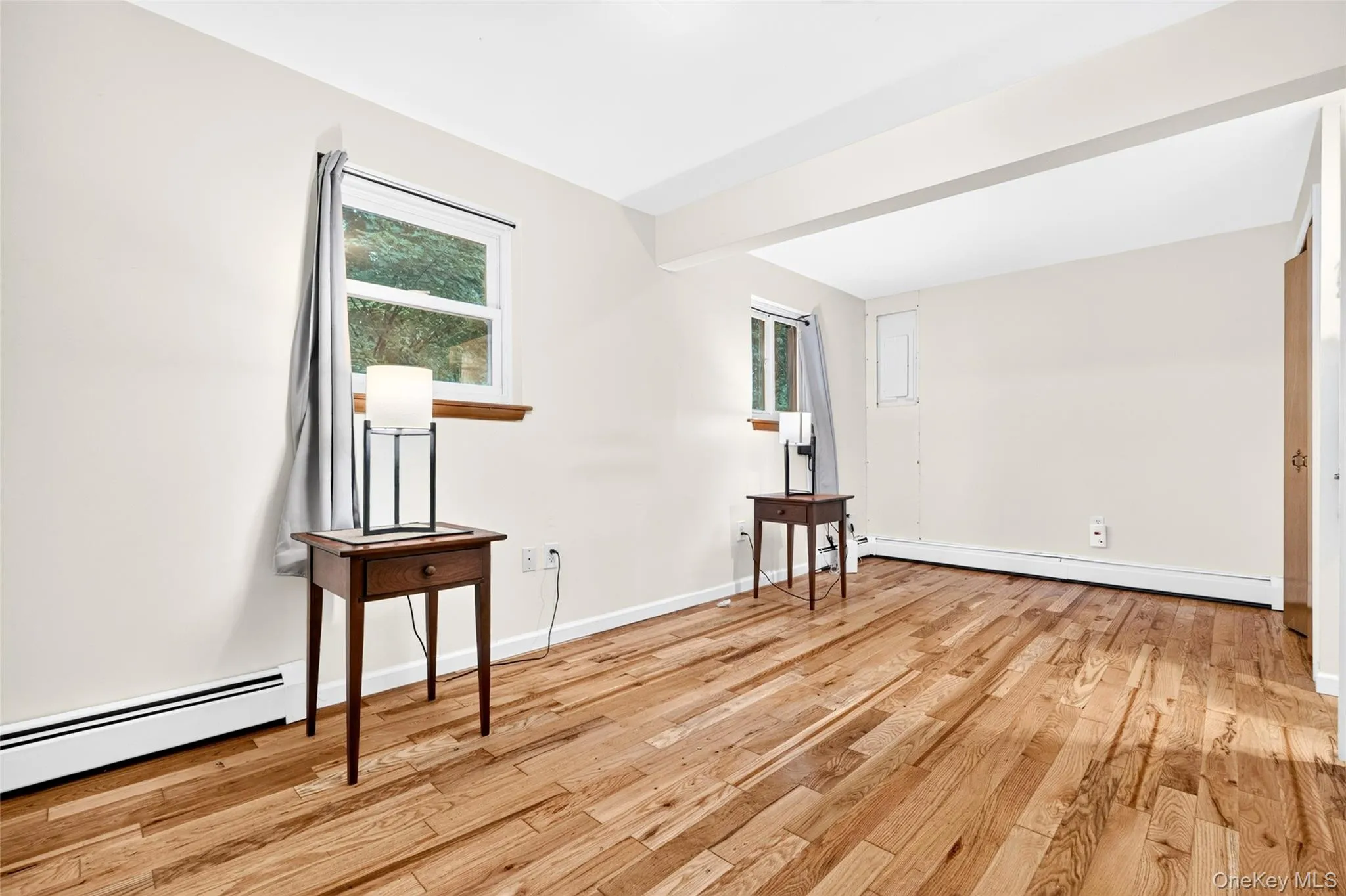 Wood-finish flooring throughout, bright white walls, and multiple windows providing natural light Wood-finish flooring throughout, bright white walls, and multiple windows providing natural light