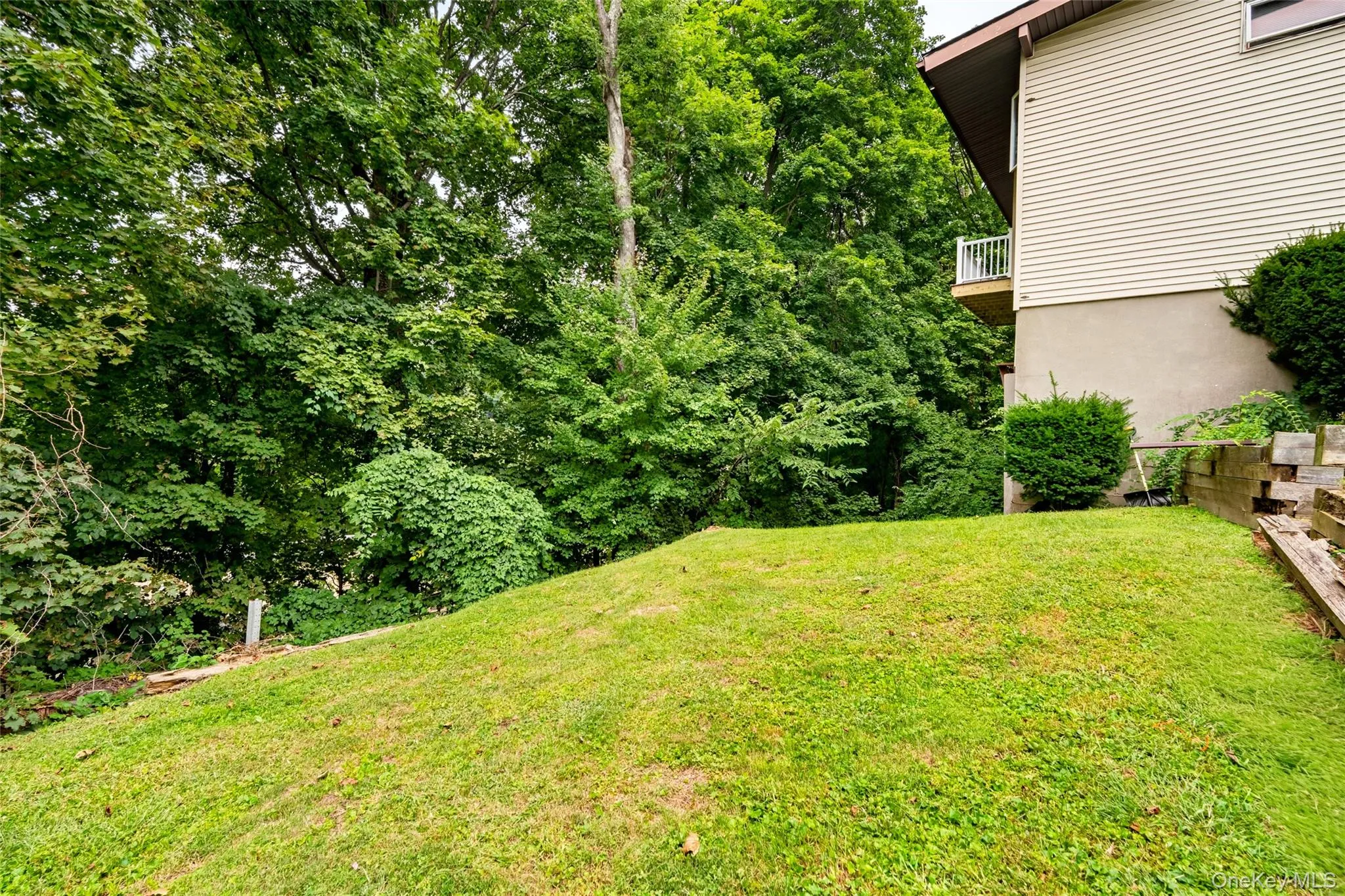 Expansive green space featuring a sloped lawn and mature trees Expansive green space featuring a sloped lawn and mature trees