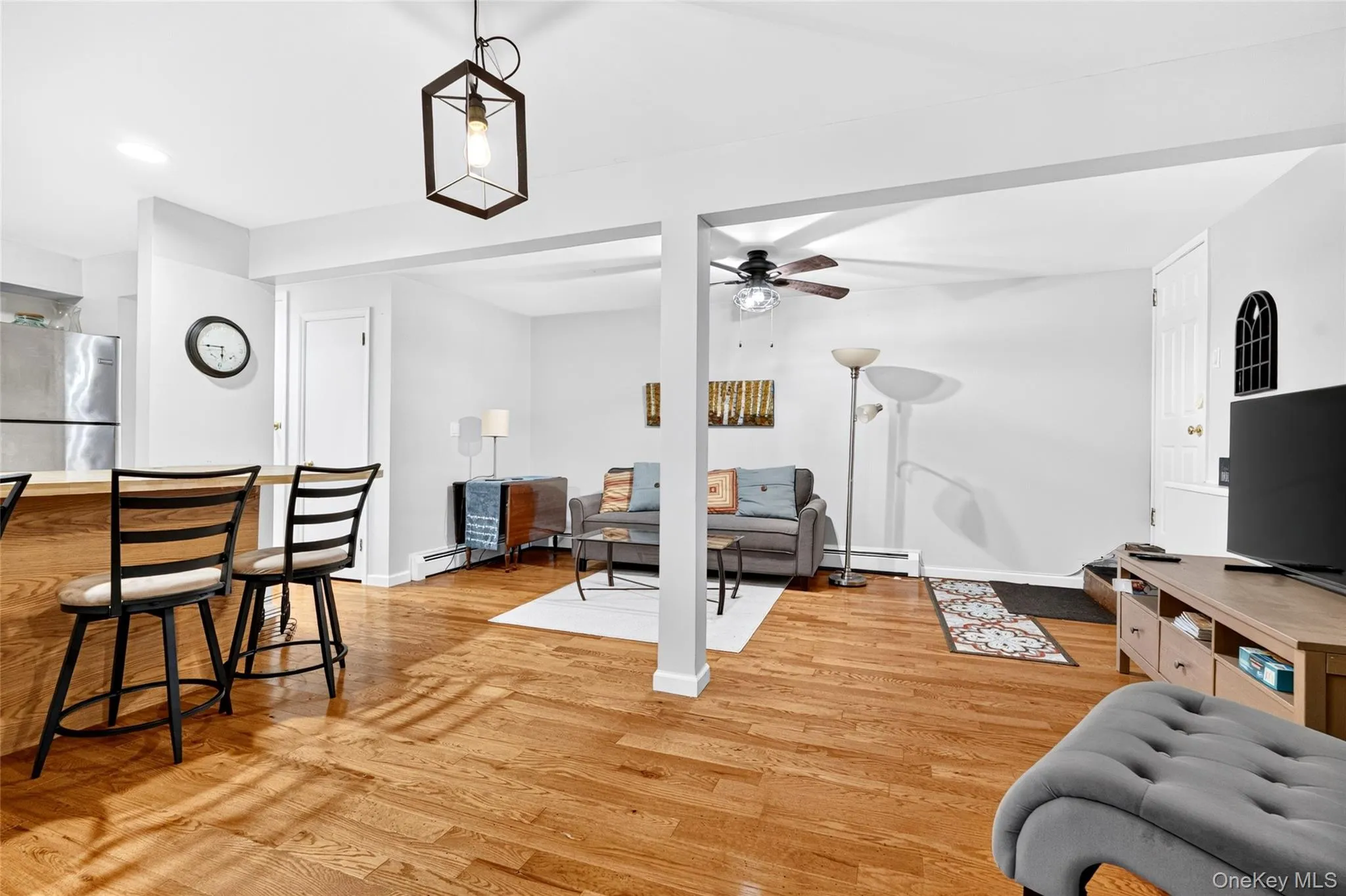 Wood-finish flooring throughout, with a breakfast bar featuring a light wood countertop Wood-finish flooring throughout, with a breakfast bar featuring a light wood countertop