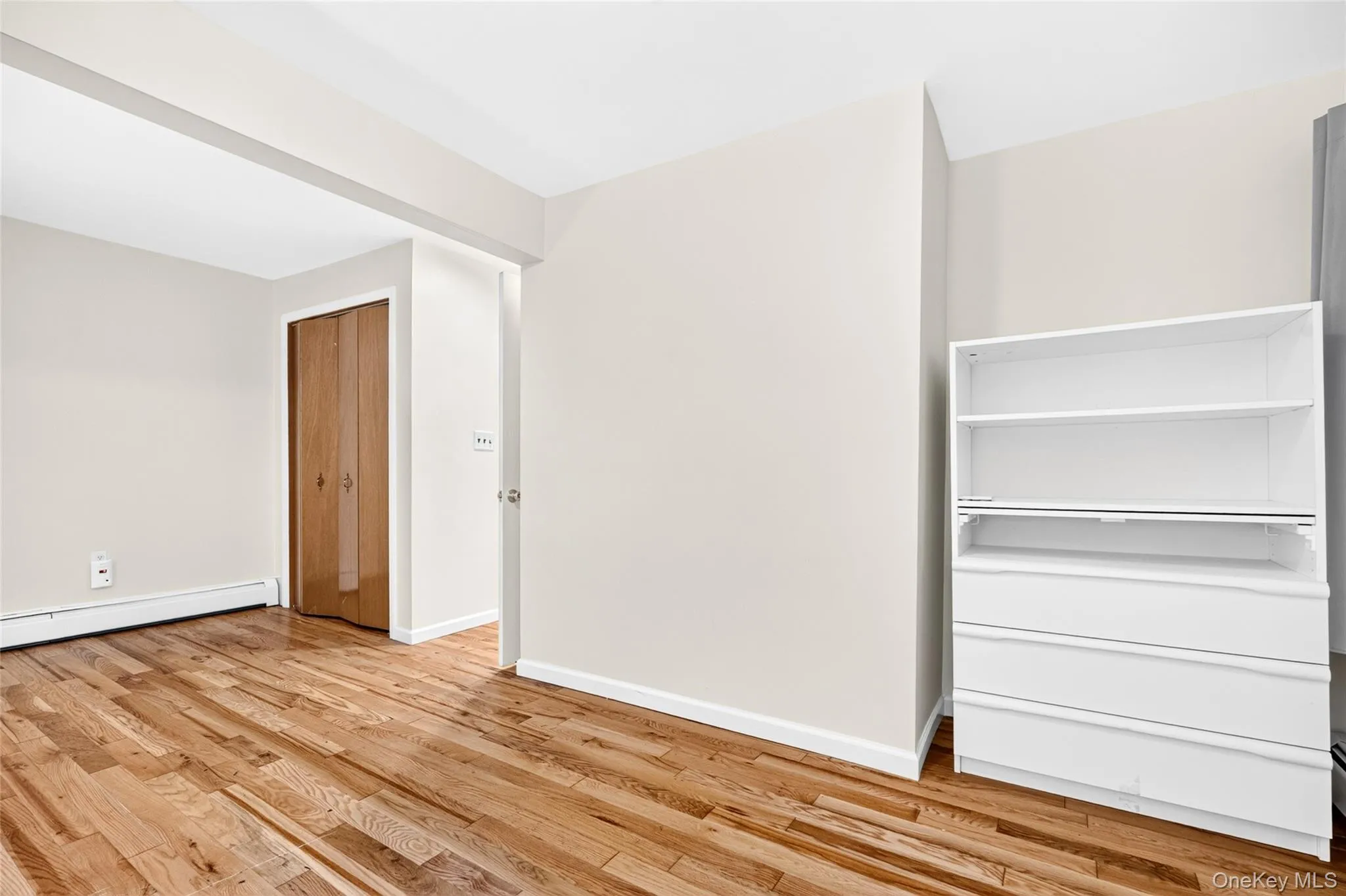 Hardwood flooring, painted walls, built-in shelving, and wood-finish bi-fold closet doors Hardwood flooring, painted walls, built-in shelving, and wood-finish bi-fold closet doors