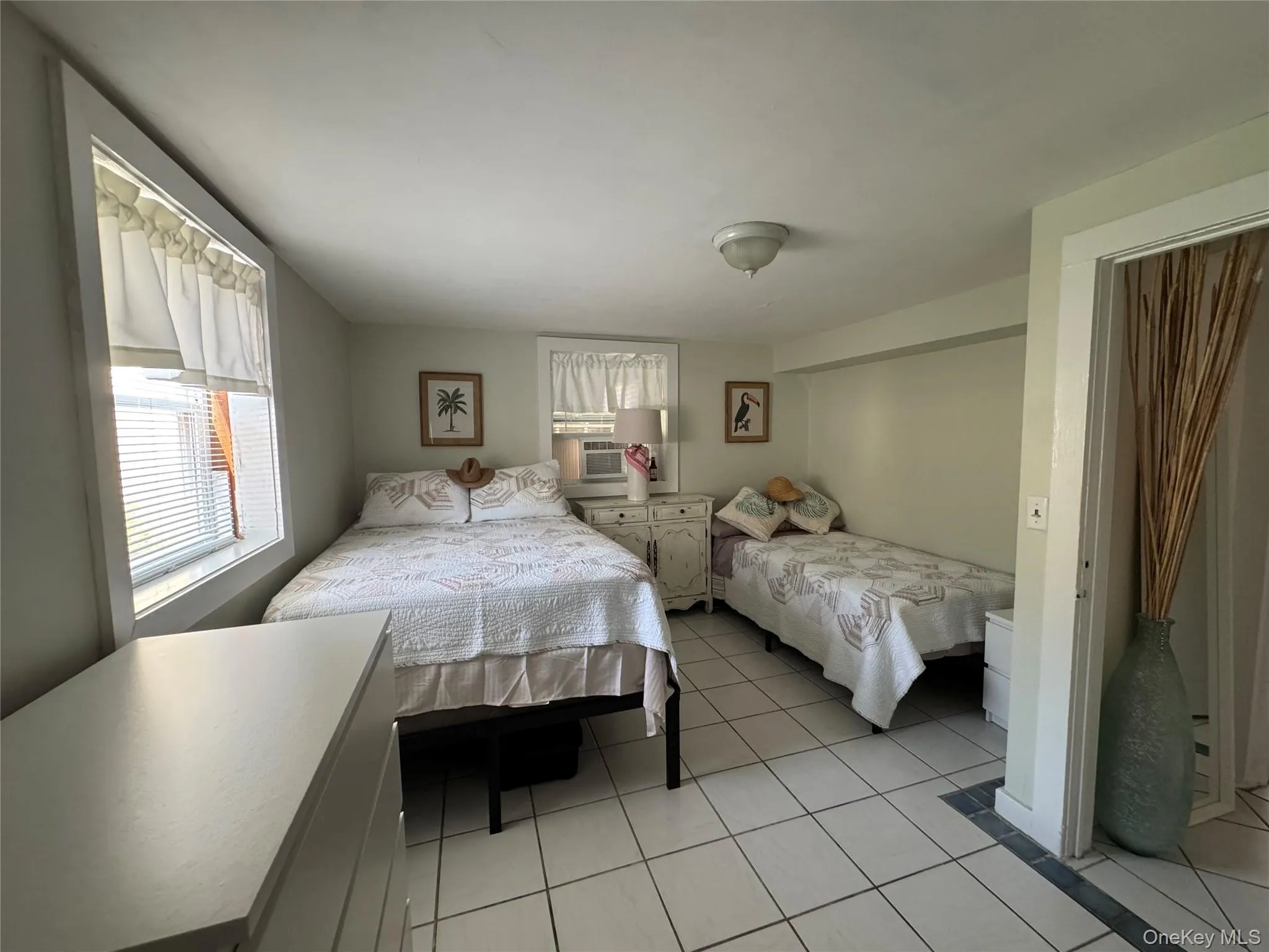 Bedroom with multiple windows and light tile patterned floors Bedroom with multiple windows and light tile patterned floors