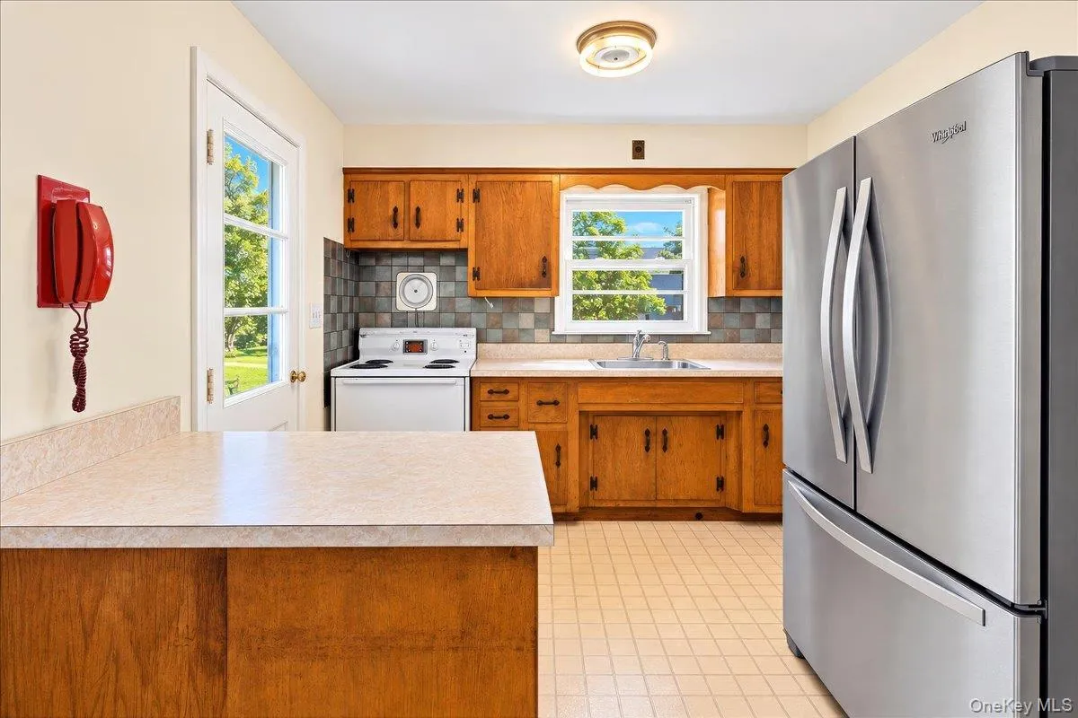 Kitchen has back door to patio and yard Kitchen has back door to patio and yard