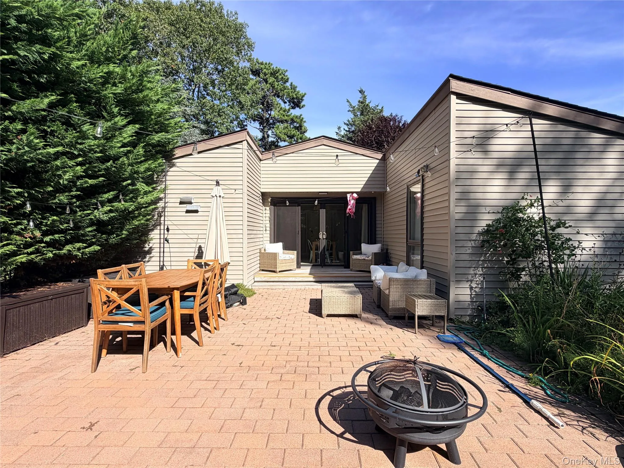 Backyard patio w/ outdoor seat ing, dining set, & firepit. Backyard patio w/ outdoor seat ing, dining set, & firepit.