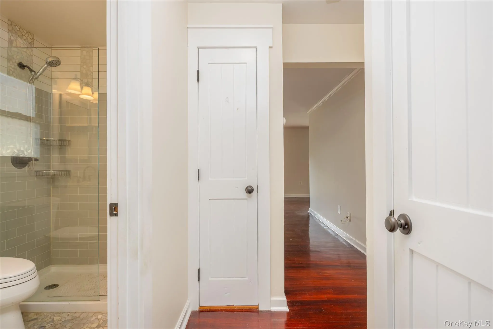 Glass-enclosed shower with subway tile surround, built-in shelving, and a shower seat Glass-enclosed shower with subway tile surround, built-in shelving, and a shower seat