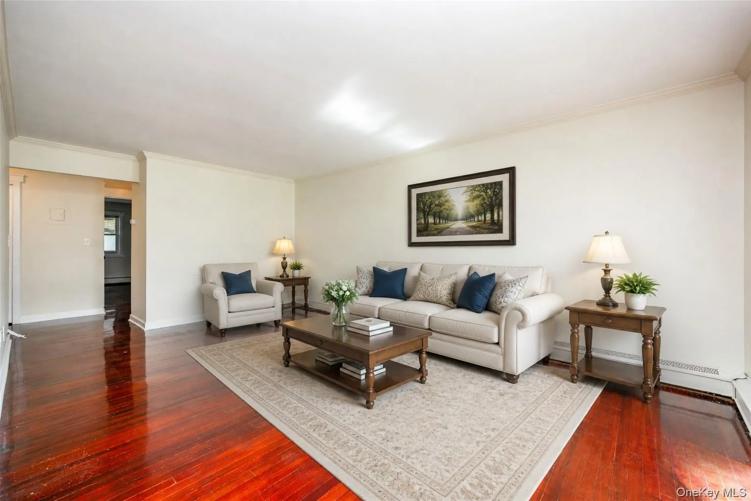 Hardwood flooring, crown molding, and neutral wall tones. Staged photo Hardwood flooring, crown molding, and neutral wall tones. Staged photo