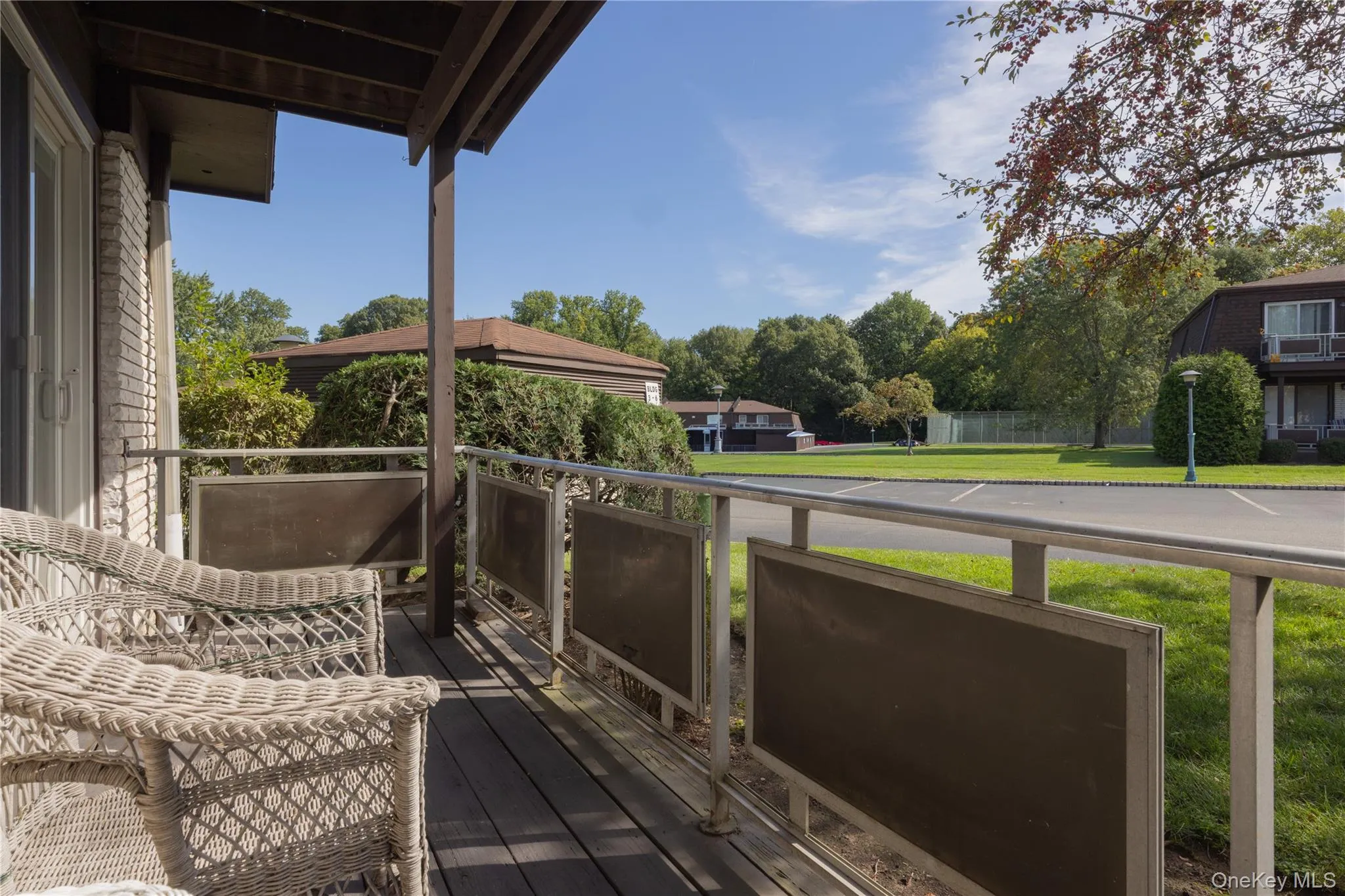 Covered porch with wood-finish flooring and a metal railing Covered porch with wood-finish flooring and a metal railing