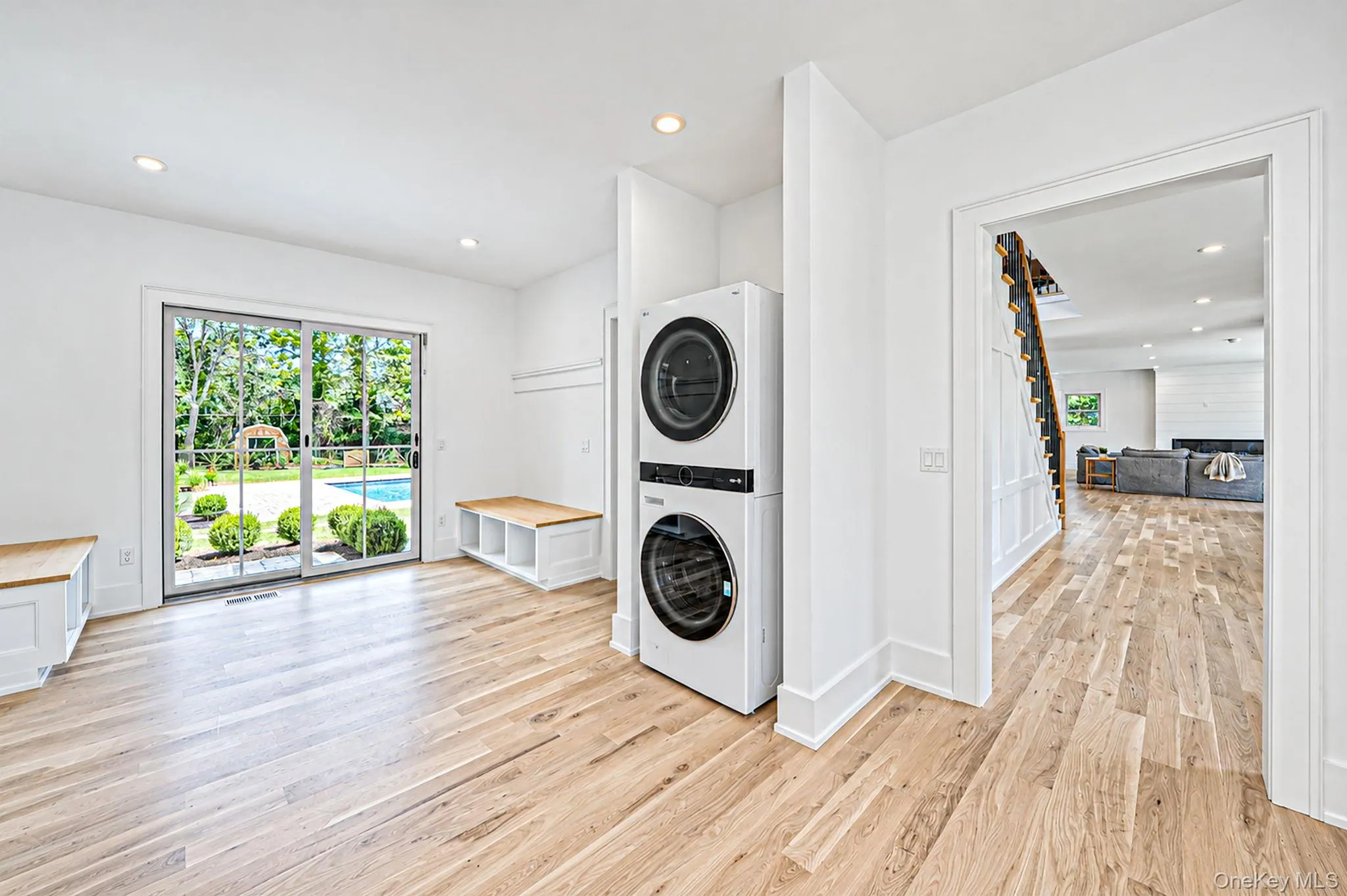 Wide plank wood-finish flooring, built-in storage benches with wood tops, recessed lighting, and a glass sliding door to the exterior and laundry area Wide plank wood-finish flooring, built-in storage benches with wood tops, recessed lighting, and a glass sliding door to the exterior and laundry area