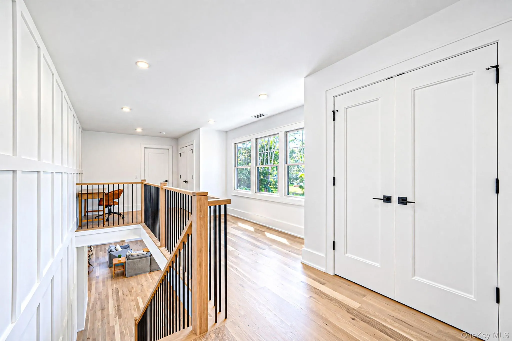 Hardwood flooring throughout, featuring a natural wood-finish staircase with black metal balusters Hardwood flooring throughout, featuring a natural wood-finish staircase with black metal balusters
