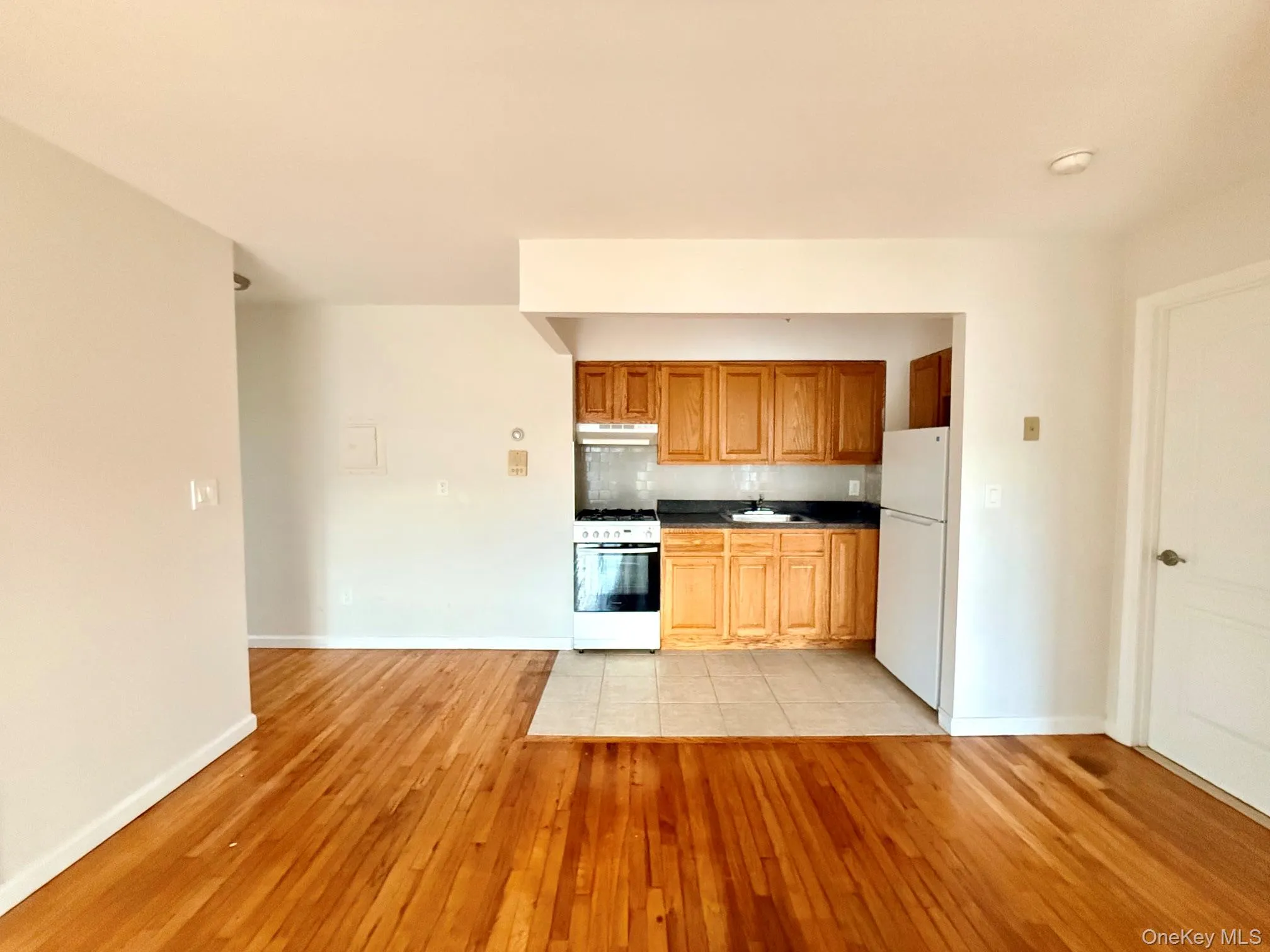 Wood-finish flooring throughout, with a tiled kitchen area Wood-finish flooring throughout, with a tiled kitchen area