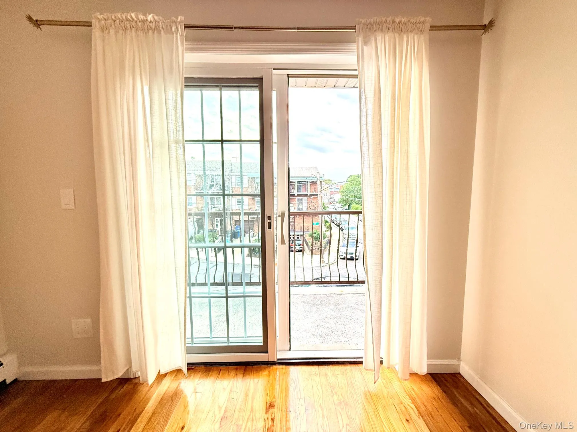 Sliding glass door with an integrated security gate, leading to an exterior balcony with wrought iron railing Sliding glass door with an integrated security gate, leading to an exterior balcony with wrought iron railing