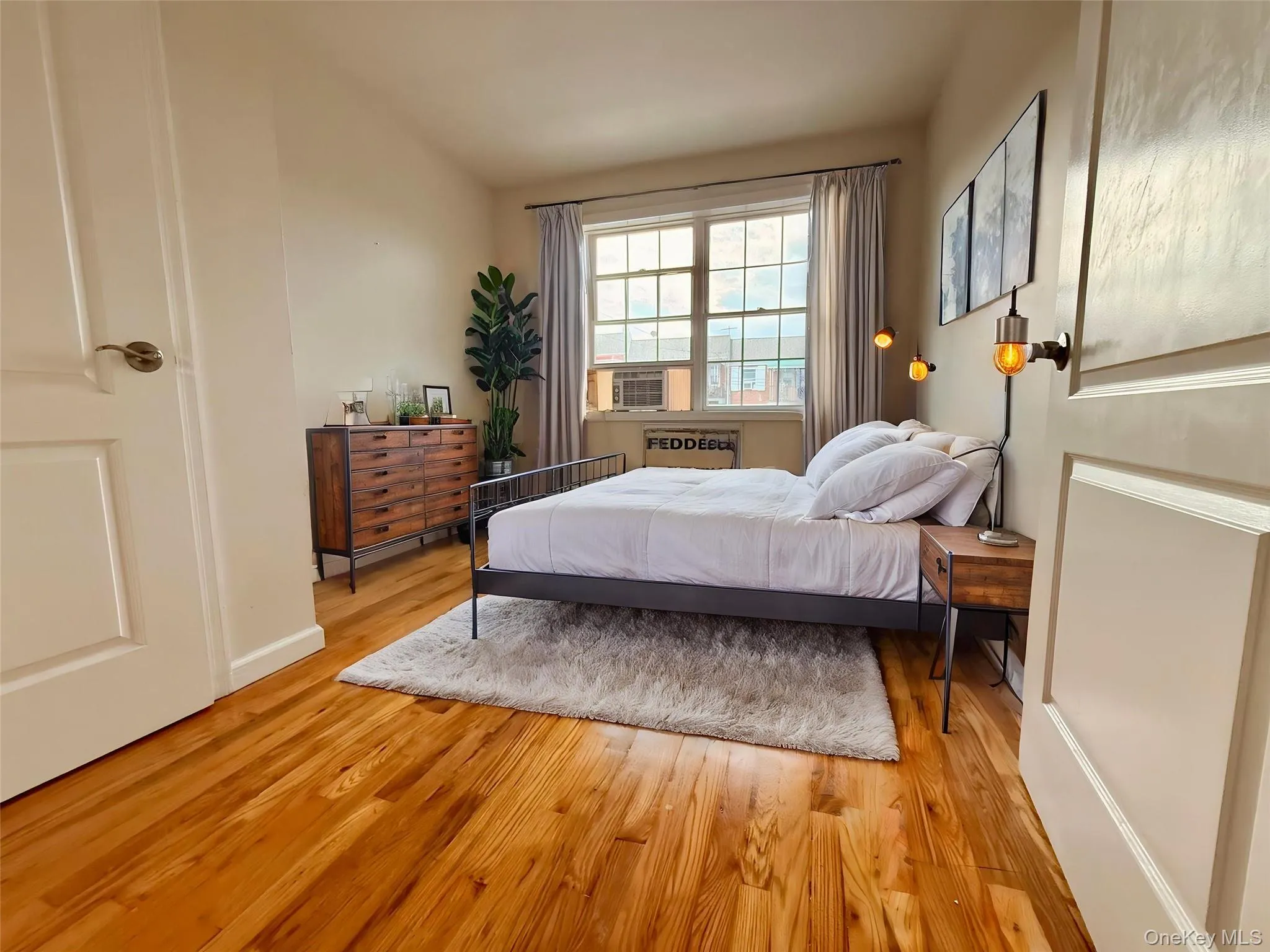 Hardwood flooring throughout, large window with ample natural light, and a built-in wall sconce Hardwood flooring throughout, large window with ample natural light, and a built-in wall sconce