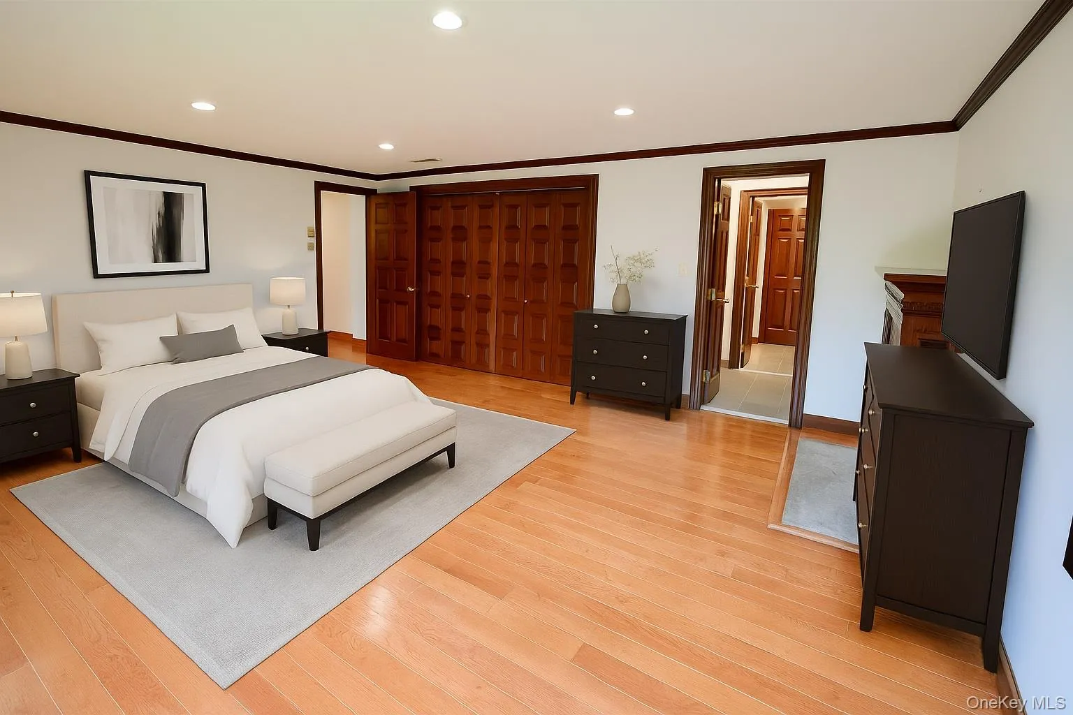 Master bedroom featuring recessed lighting, crown molding, light wood-style flooring, and a closet Master bedroom featuring recessed lighting, crown molding, light wood-style flooring, and a closet