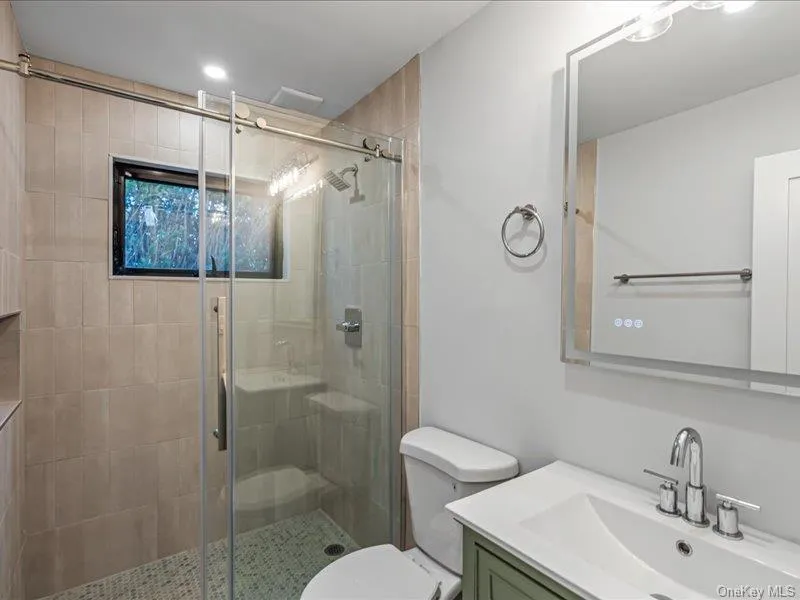 Glass-enclosed shower with tiled walls and a recessed niche Glass-enclosed shower with tiled walls and a recessed niche