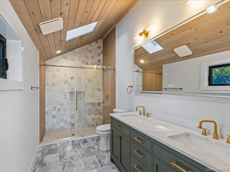 White and gray hexagonal tiled shower with glass enclosure, marble floor White and gray hexagonal tiled shower with glass enclosure, marble floor