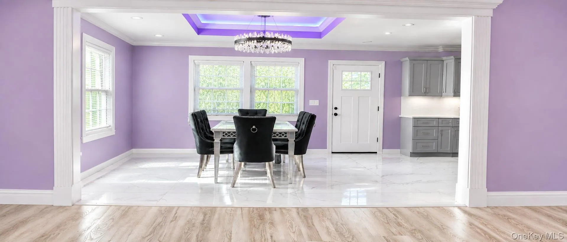 Recessed ceiling with accent lighting, crystal chandelier, white trim, and large windows Recessed ceiling with accent lighting, crystal chandelier, white trim, and large windows