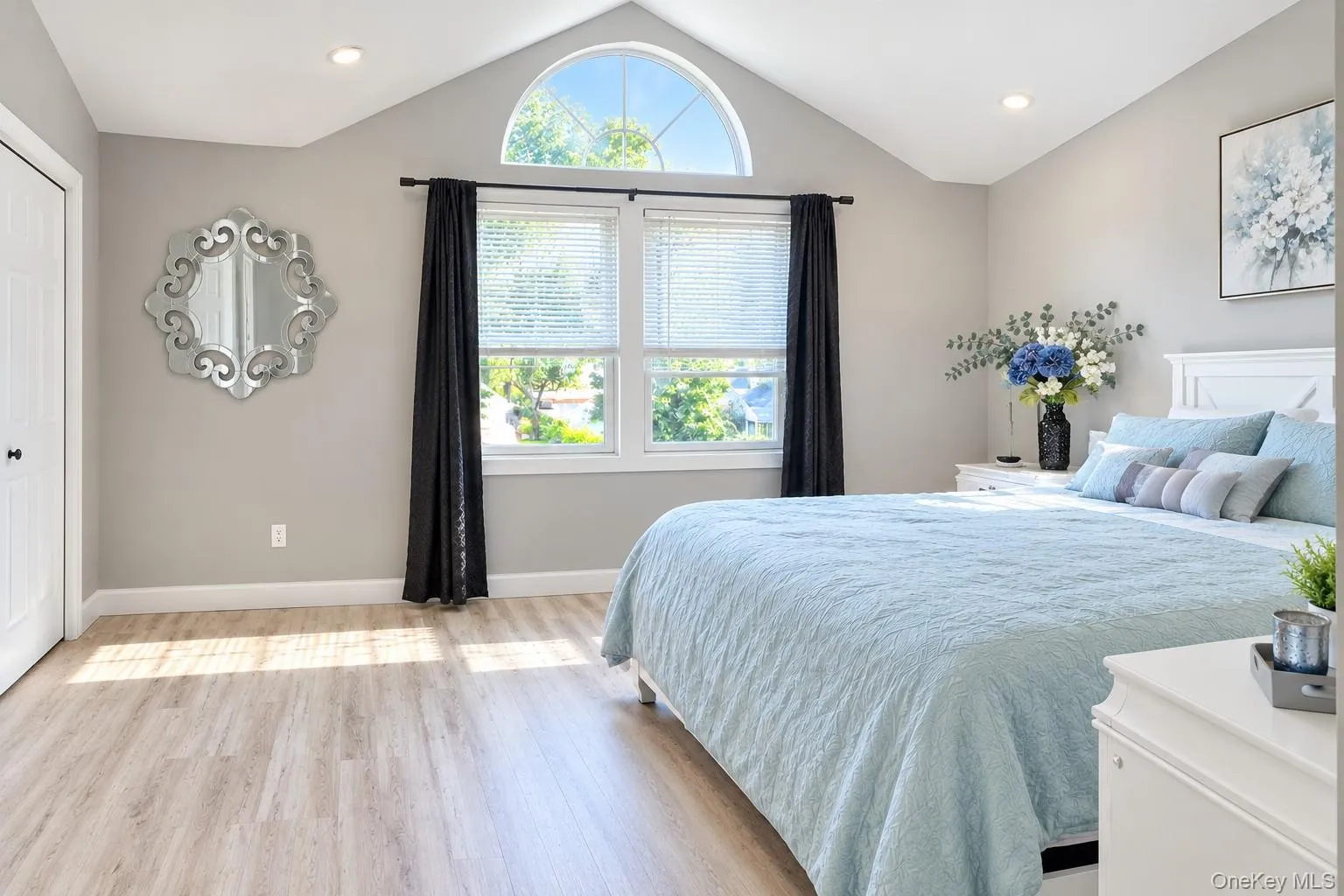 Vaulted ceiling with an arched window, finished flooring, and recessed lighting Vaulted ceiling with an arched window, finished flooring, and recessed lighting