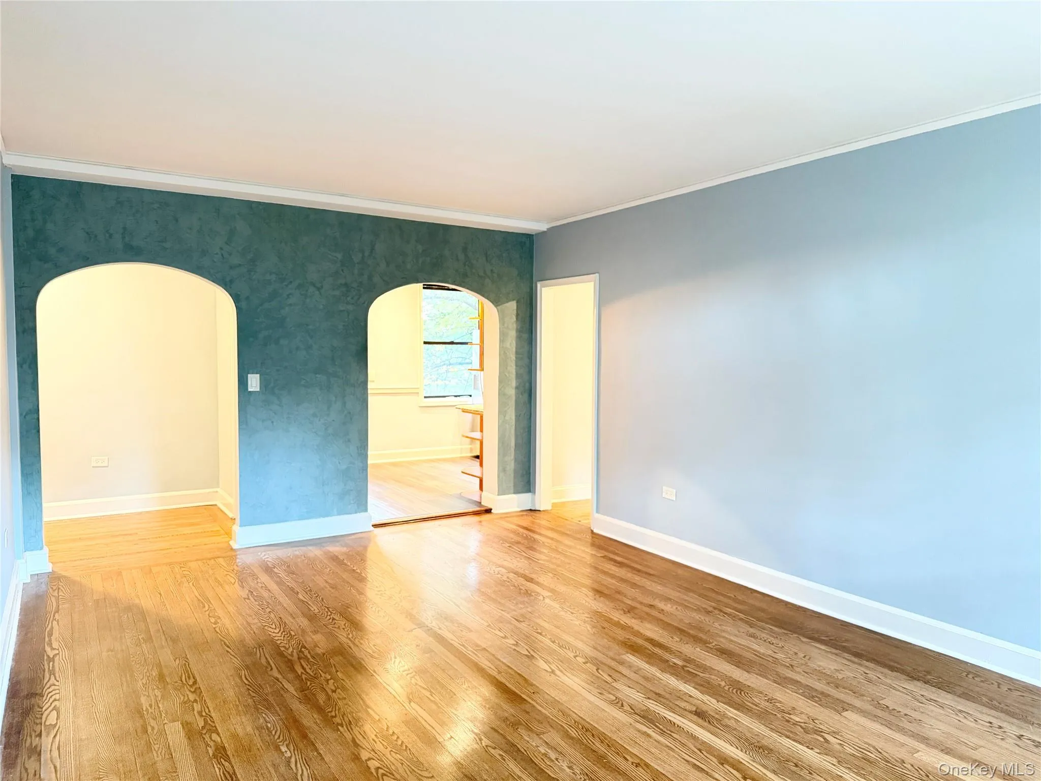 Hardwood flooring throughout, with arched doorways and crown molding Hardwood flooring throughout, with arched doorways and crown molding