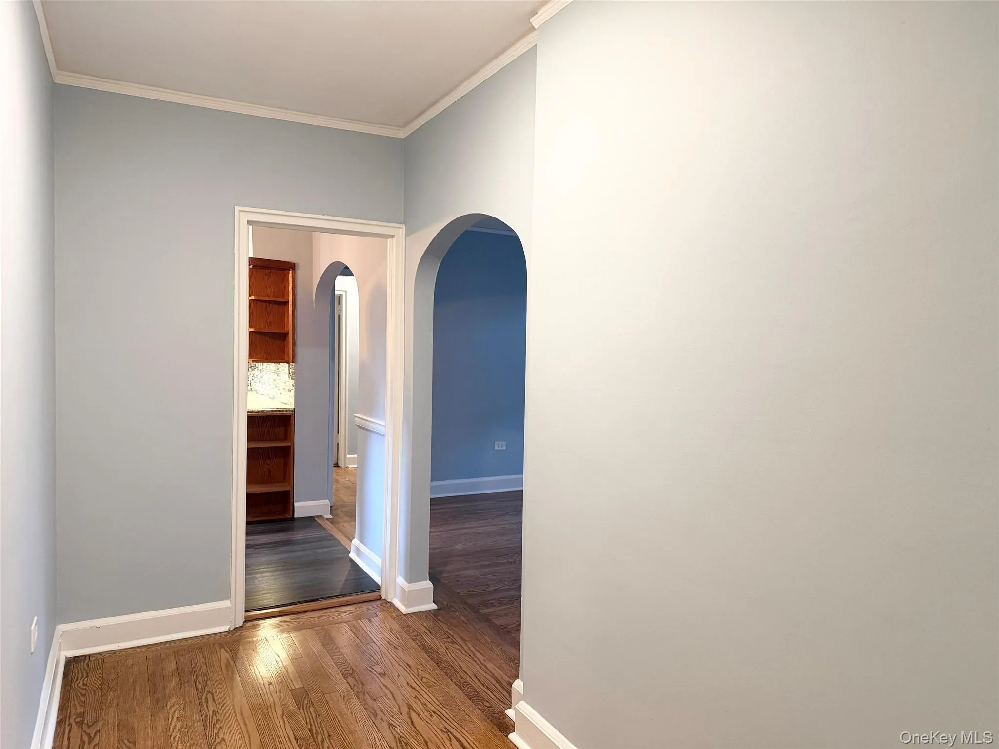 Hardwood flooring with white trim, arched doorway. Hardwood flooring with white trim, arched doorway.