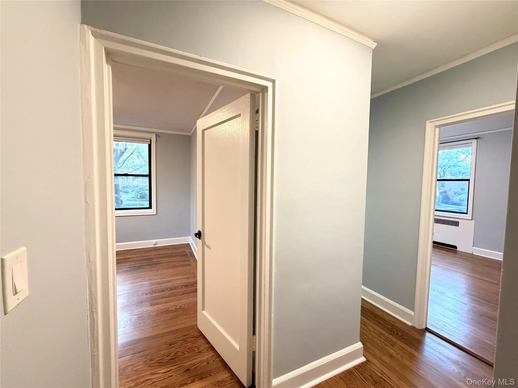 Hardwood flooring, painted walls, white trim, and white doors with dark hardware Hardwood flooring, painted walls, white trim, and white doors with dark hardware