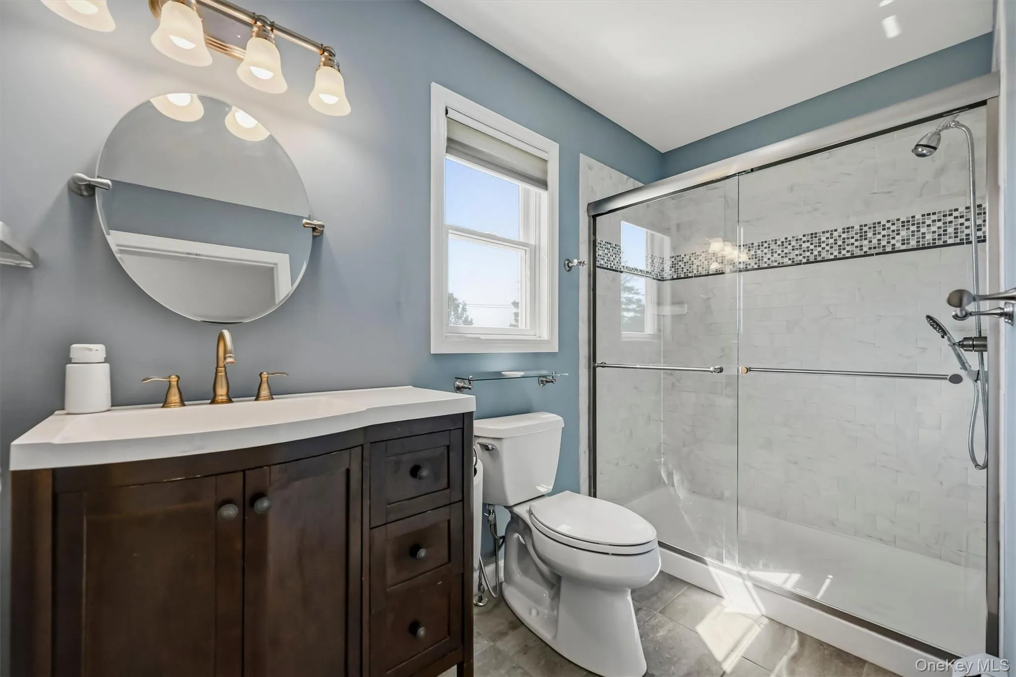 Dark wood-finish vanity with a white countertop and brass-finish faucet Dark wood-finish vanity with a white countertop and brass-finish faucet