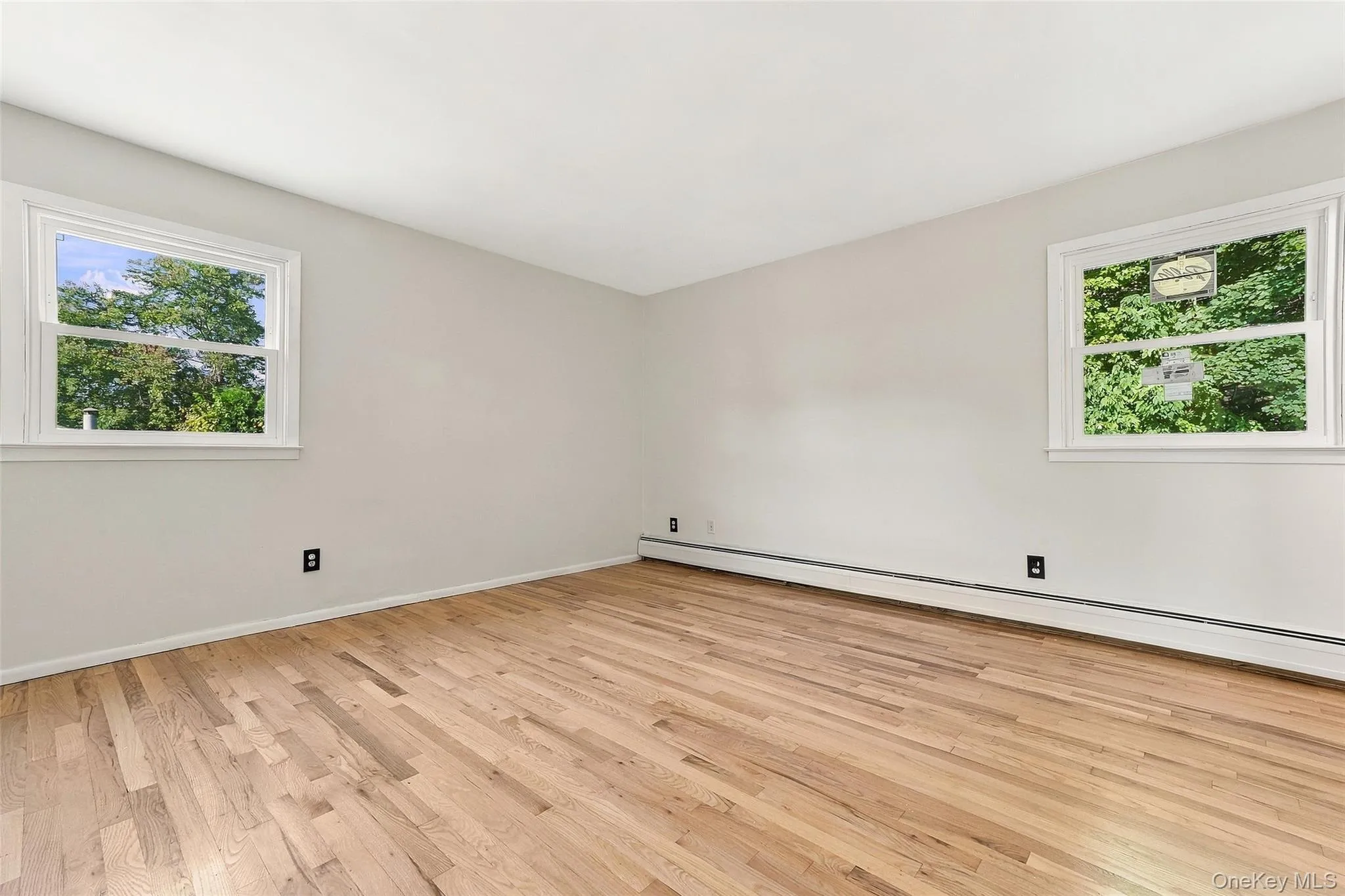 Primary Room Hardwood flooring, white walls, and two white-framed windows Primary Room Hardwood flooring, white walls, and two white-framed windows