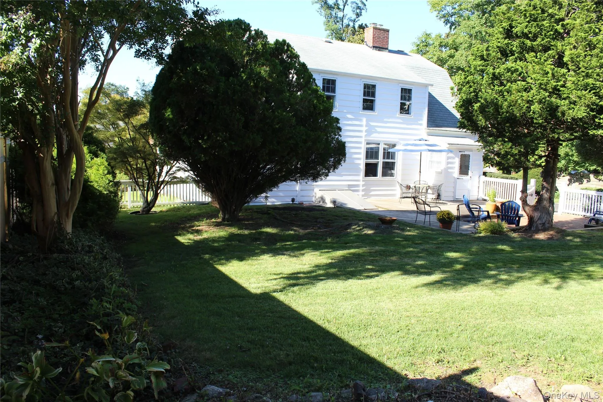 White siding exterior with a shingle roof, accompanied by a brick patio and deck . Back door to Kitchen. White siding exterior with a shingle roof, accompanied by a brick patio and deck . Back door to Kitchen.