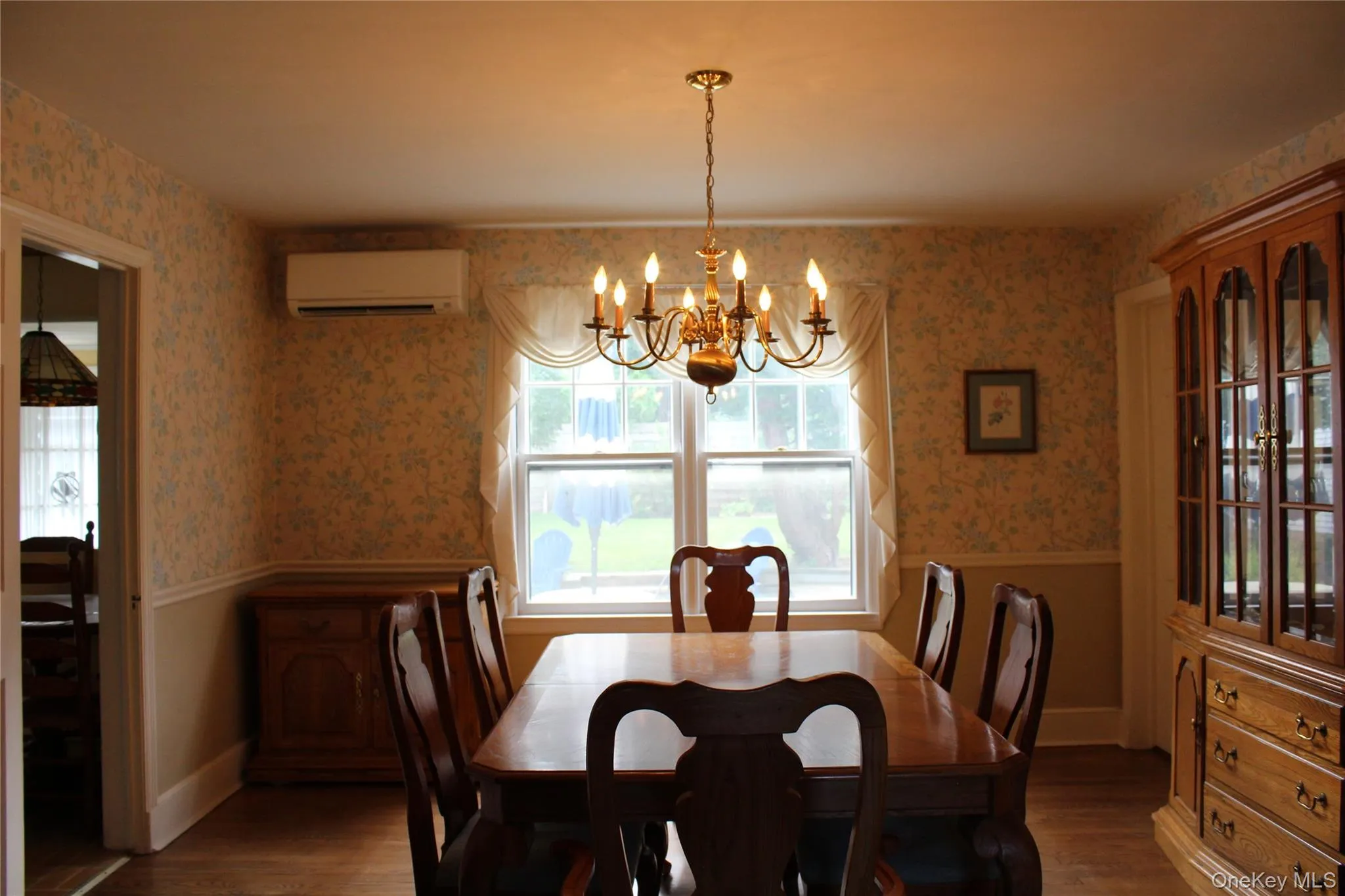 Hardwood flooring, a brass chandelier, a built-in AC split unit, and a window over looking back yard Hardwood flooring, a brass chandelier, a built-in AC split unit, and a window over looking back yard