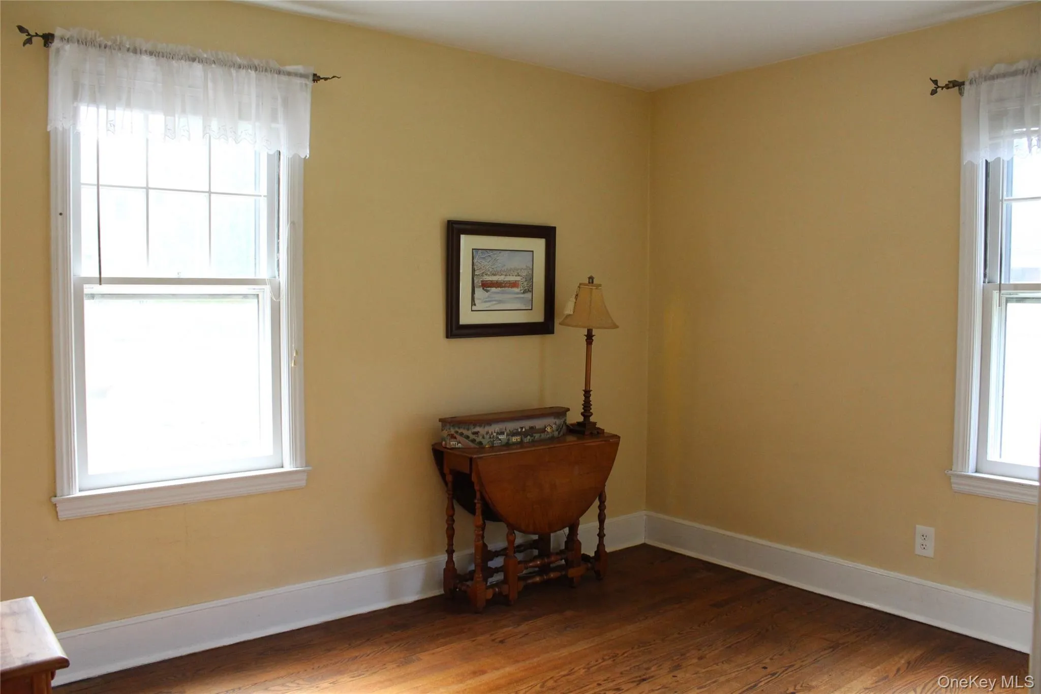 Hardwood flooring, painted walls, white window trim, and white baseboards Hardwood flooring, painted walls, white window trim, and white baseboards