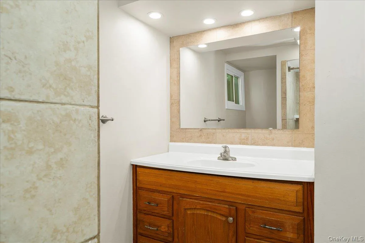 Bathroom featuring window, vanity and mirror. Bathroom featuring window, vanity and mirror.