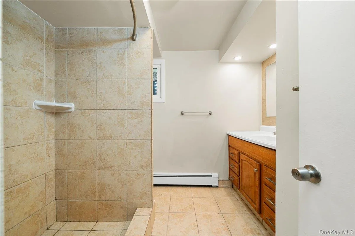 Bathroom featuring tiled shower, tile floors and vanity. Bathroom featuring tiled shower, tile floors and vanity.