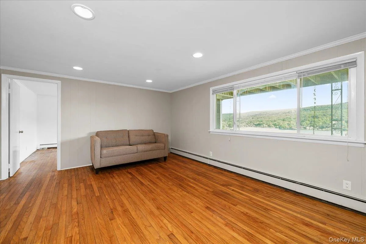 A large living room window takes in the stunning lake, sky and forest views. A large living room window takes in the stunning lake, sky and forest views.