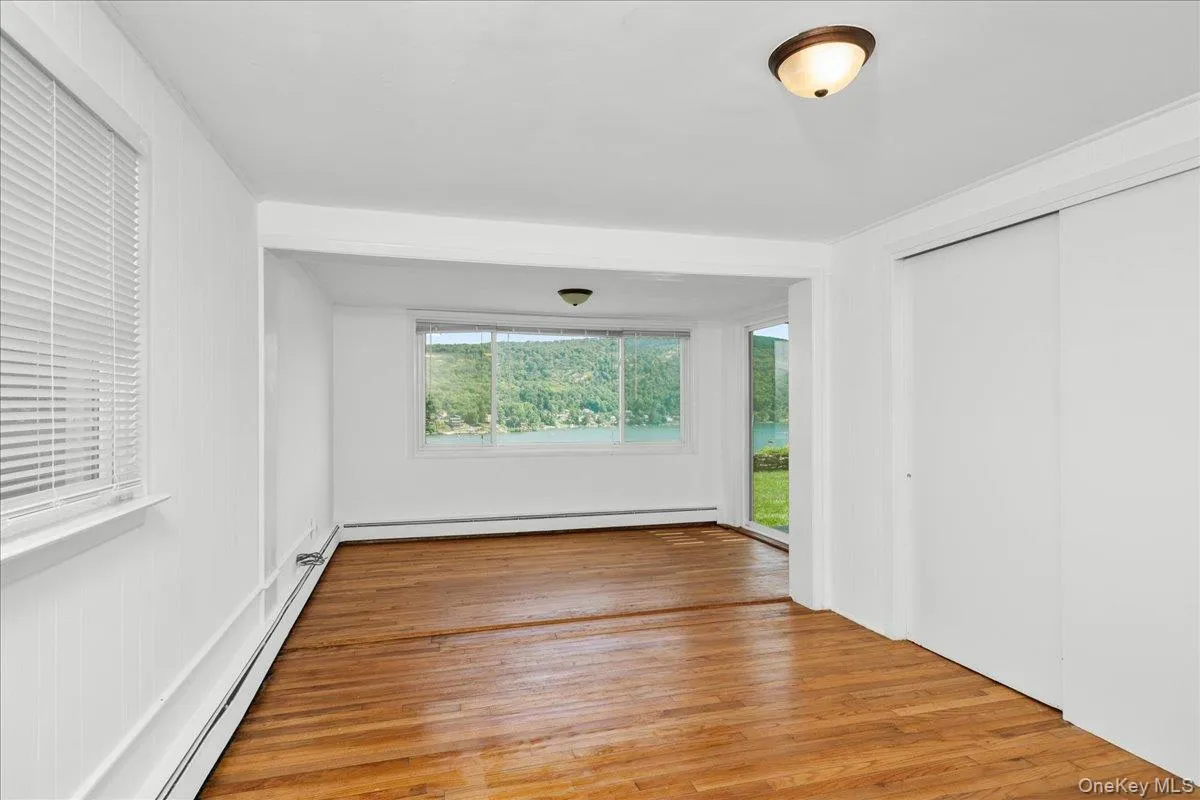 Large bedroom featuring lake views, double closet and sliders to patio. Large bedroom featuring lake views, double closet and sliders to patio.