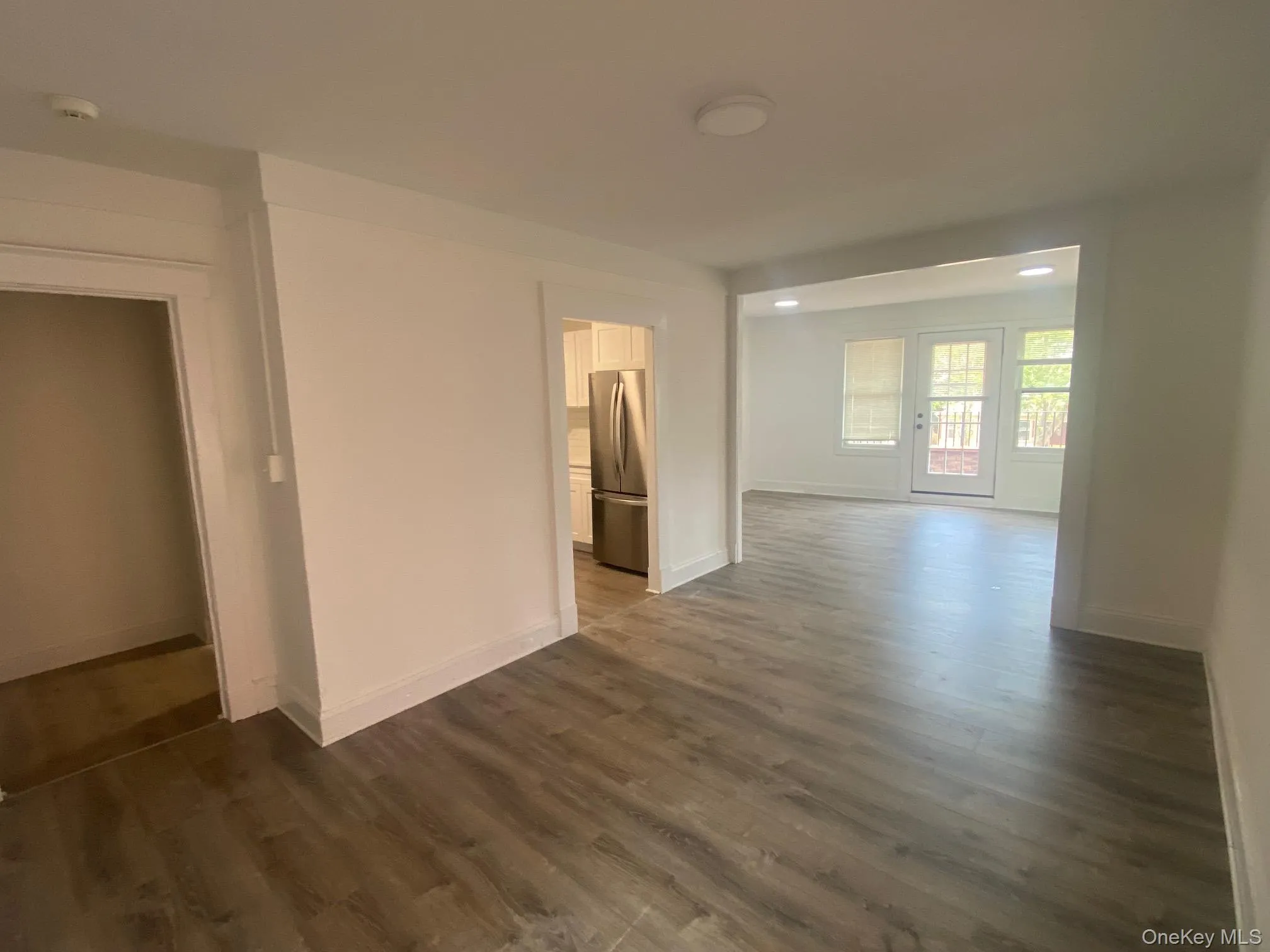Spare room featuring a smoke detector and dark wood-type flooring Spare room featuring a smoke detector and dark wood-type flooring